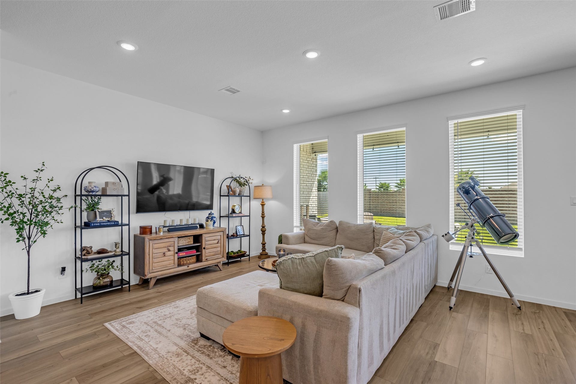 13213 Harbor Point Drive, Texas City, TX 77539 Bright and inviting living room with large windows, comfortable sectional sofa, and elegant wood flooring, perfect for relaxation and entertaining.