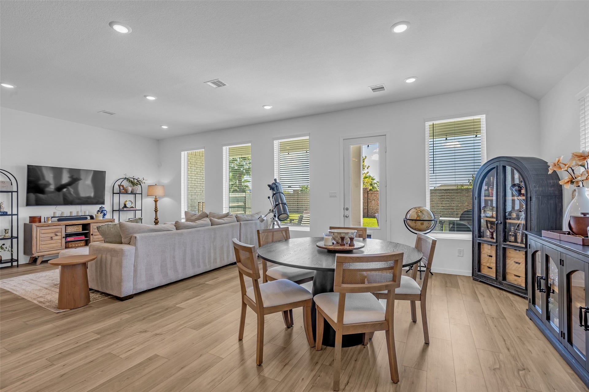 13213 Harbor Point Drive, Texas City, TX 77539 Spacious and bright open-concept living and dining area featuring sleek hardwood floors, abundant natural light from large windows, and elegant modern furnishings.
