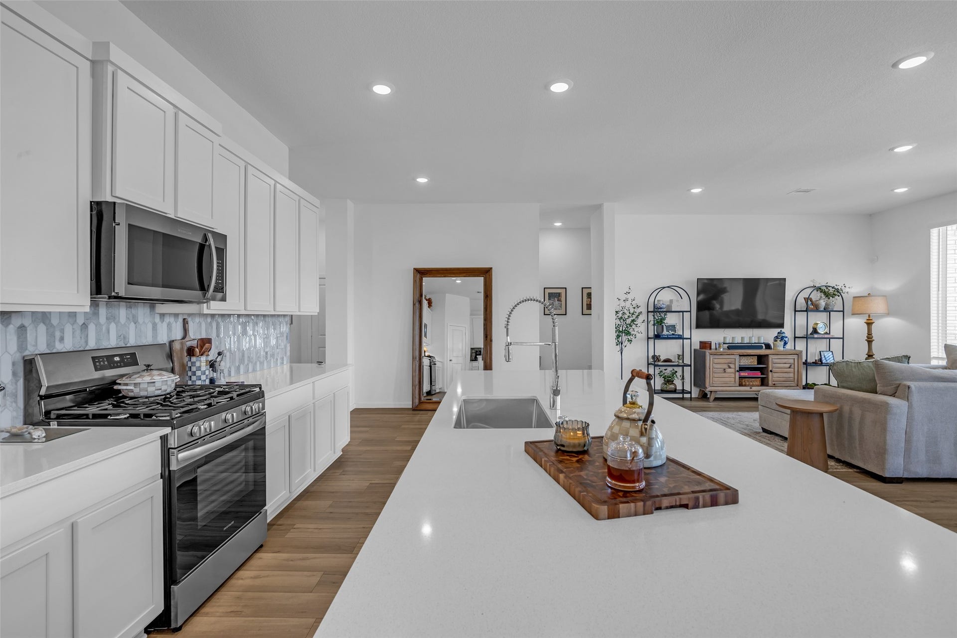 13213 Harbor Point Drive, Texas City, TX 77539 Experience modern living in this open-concept kitchen and living area, featuring sleek stainless steel appliances, ample cabinetry, and a spacious island perfect for entertaining. The adjacent cozy living space offers abundant natural light and a stylish setup for relaxation.