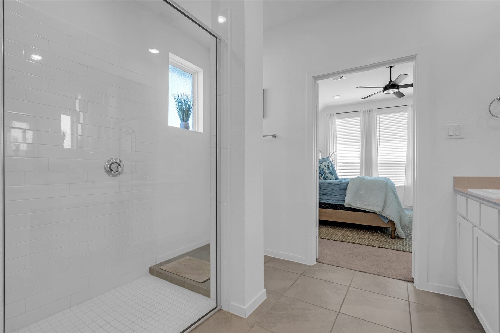 13213 Harbor Point Drive, Texas City, TX 77539 Experience the seamless flow from the elegant bathroom with a spacious glass-enclosed shower to the cozy bedroom, filled with natural light and modern finishes.