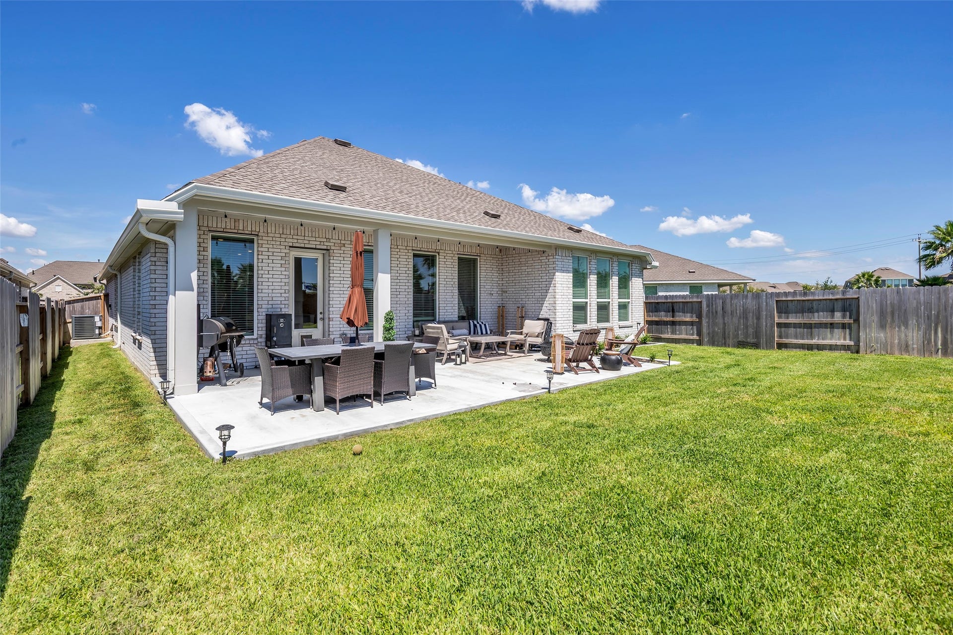 13213 Harbor Point Drive, Texas City, TX 77539 Spacious backyard with a large patio perfect for outdoor dining and relaxation, surrounded by a well-maintained lawn and privacy fence.