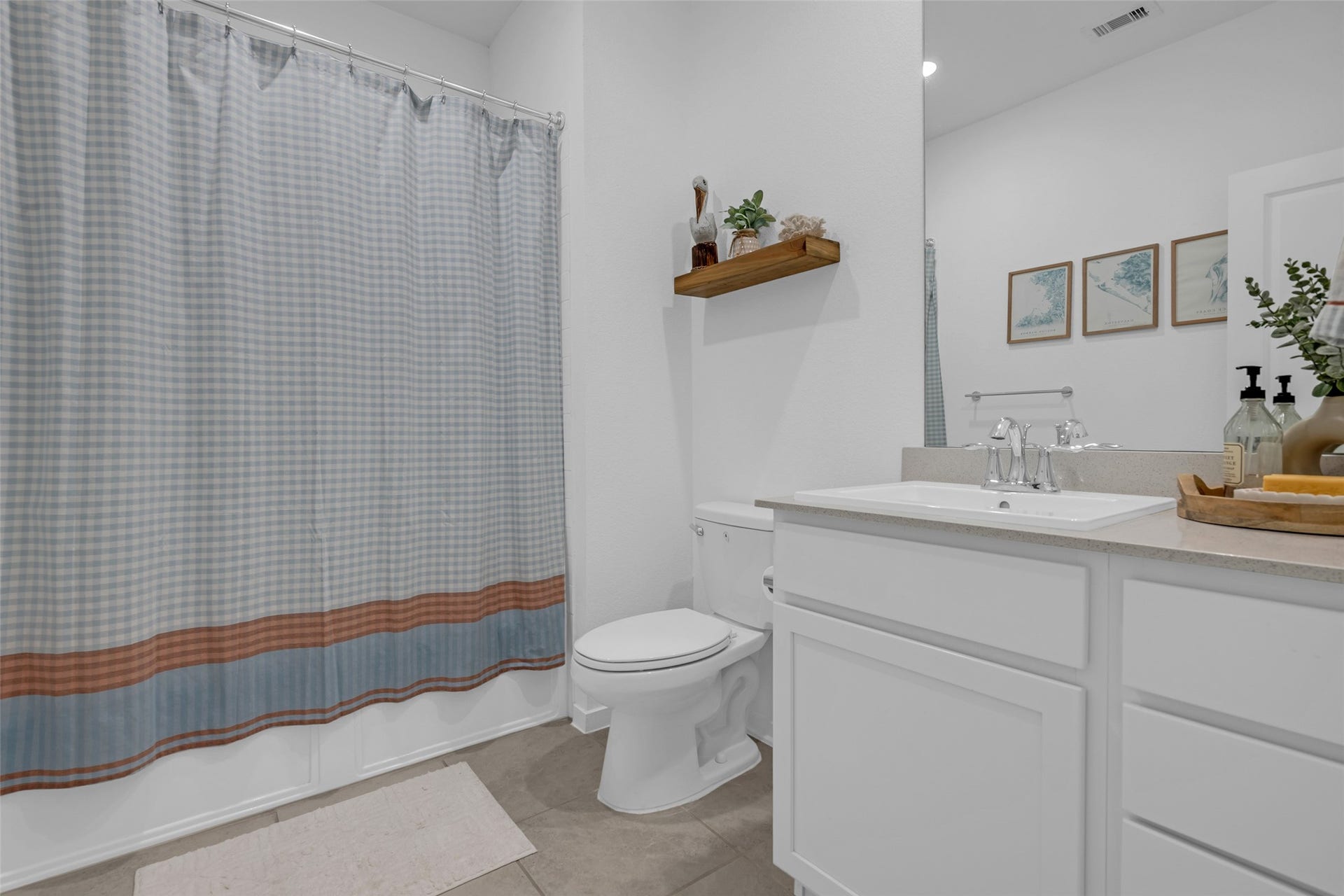 13213 Harbor Point Drive, Texas City, TX 77539 Charming bathroom with a modern sink vanity, stylish shelving, and tasteful decor.