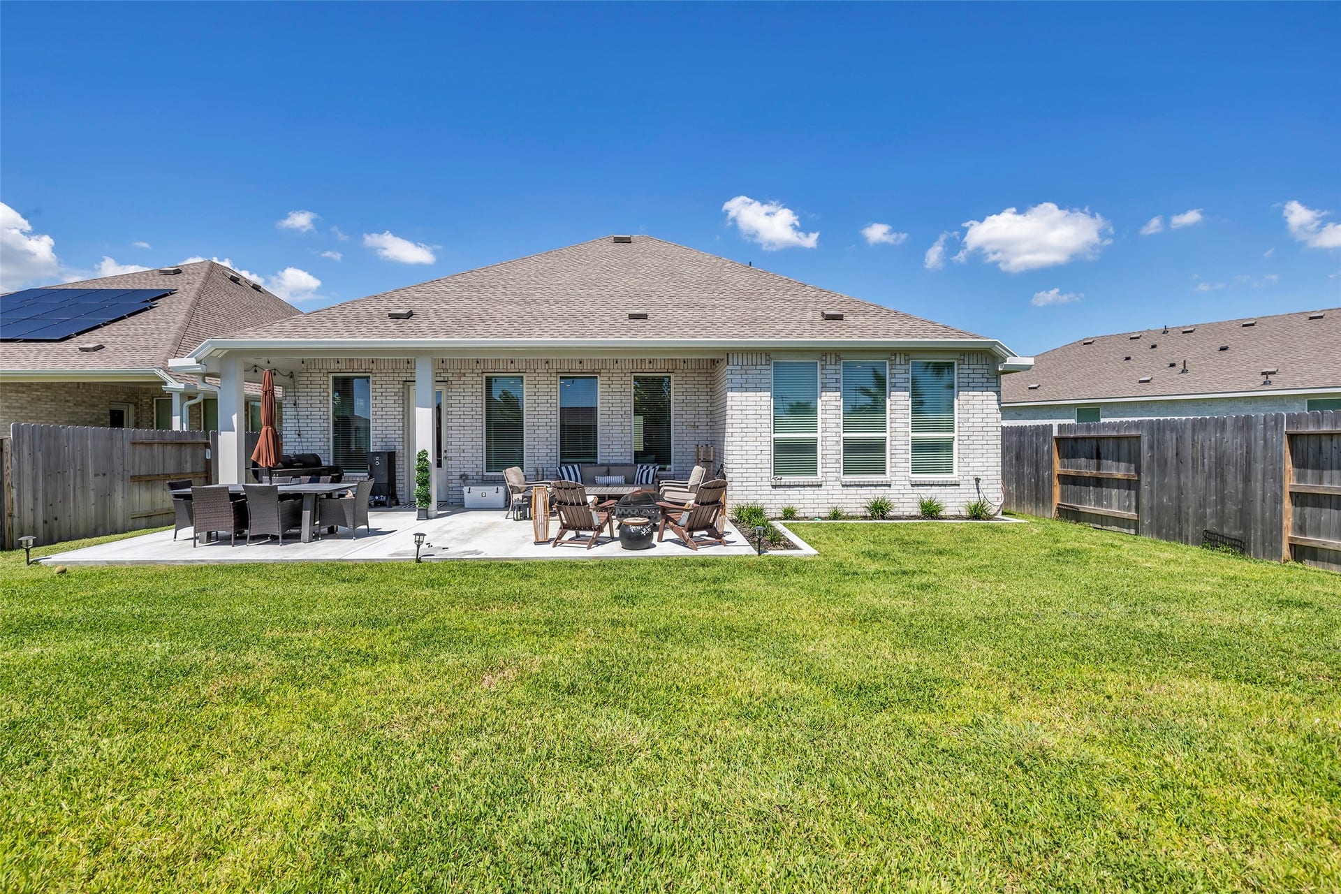13213 Harbor Point Drive, Texas City, TX 77539 Spacious backyard with a well-maintained lawn, featuring a modern patio area perfect for outdoor dining and entertaining.