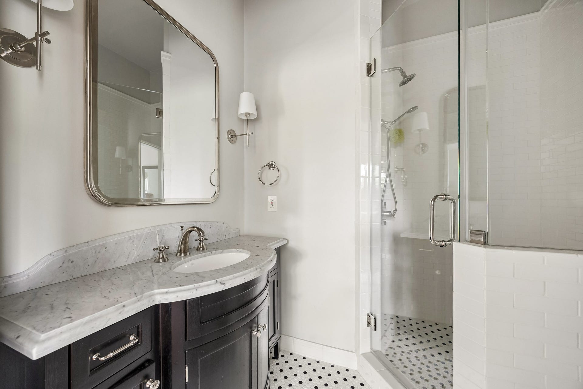 8 Courtlandt Place, Houston, TX 77006 Tastefully updated en suite bath featuring a marble-topped vanity, polished nickel fixtures and glass-enclosed shower with classic tile detailing.