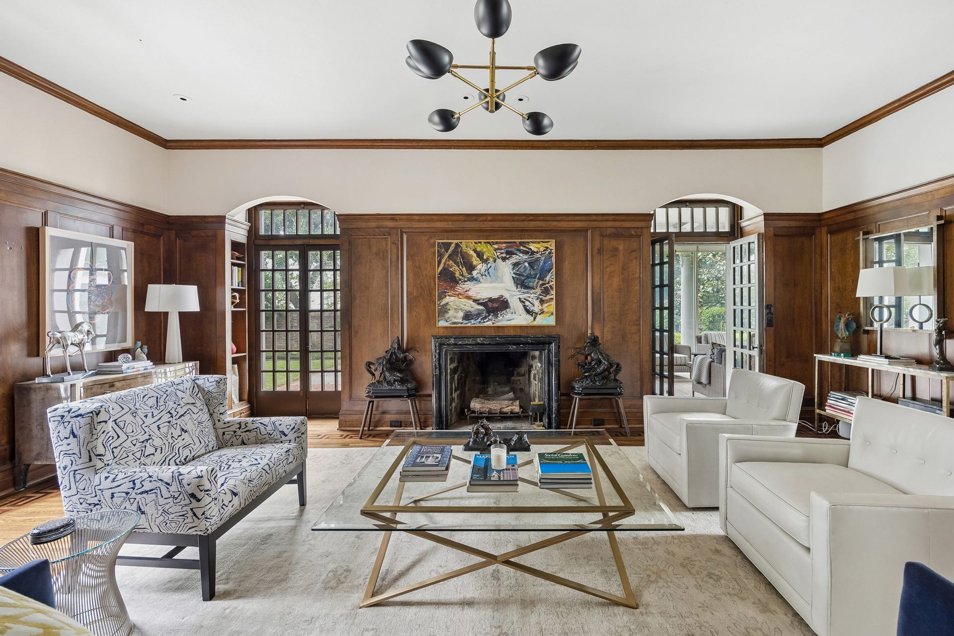 8 Courtlandt Place, Houston, TX 77006 Rich wood paneling, a striking black marble fireplace surround, and exquisite architectural detailing lend timeless warmth and character to this inviting gathering space, reflecting the home's rich architectural heritage and extensive renovations by renowned architect John F. Staub.