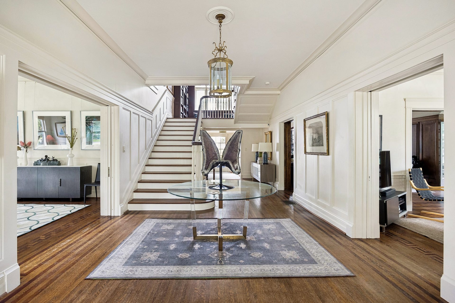 8 Courtlandt Place, Houston, TX 77006 The impressive central hall features a sweeping staircase and beautifully preserved wood flooring, providing access to the home's principal living spaces.