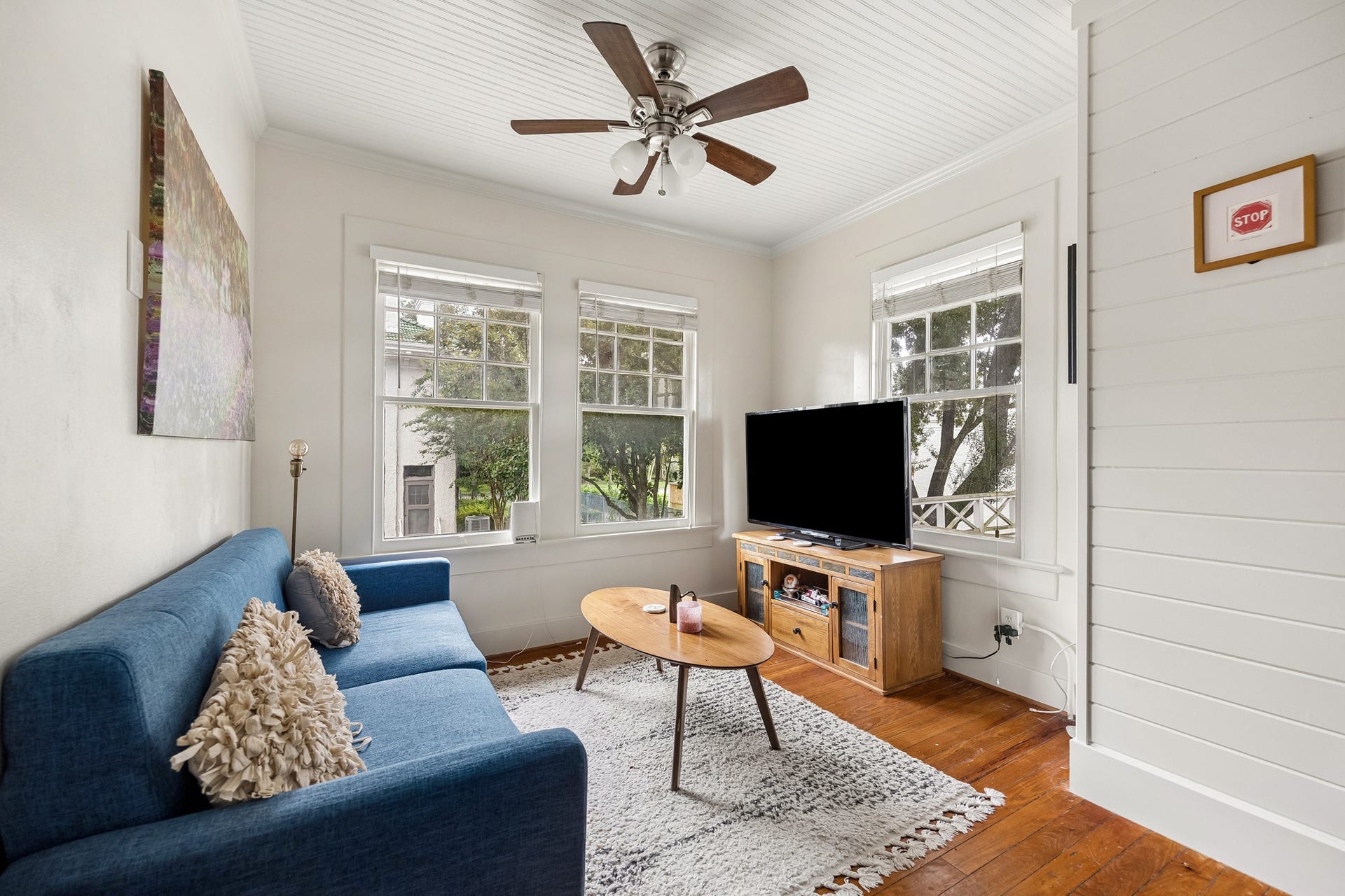 8 Courtlandt Place, Houston, TX 77006 A comfortable living area with beadboard ceiling, wood flooring and multiple windows creates a welcoming space within the separate garage apartment.