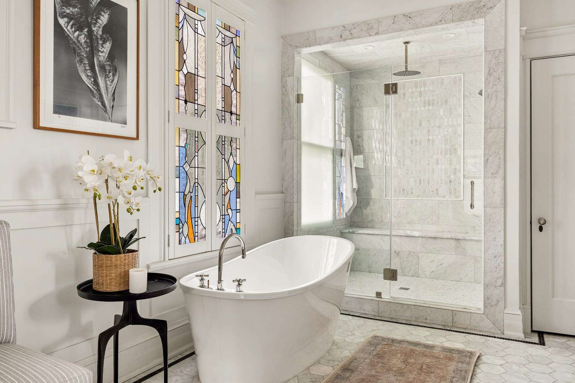 8 Courtlandt Place, Houston, TX 77006 A closer look reveals the bath's striking stained-glass detailing, sculptural soaking tub and luxurious marble shower with decorative tile accents.