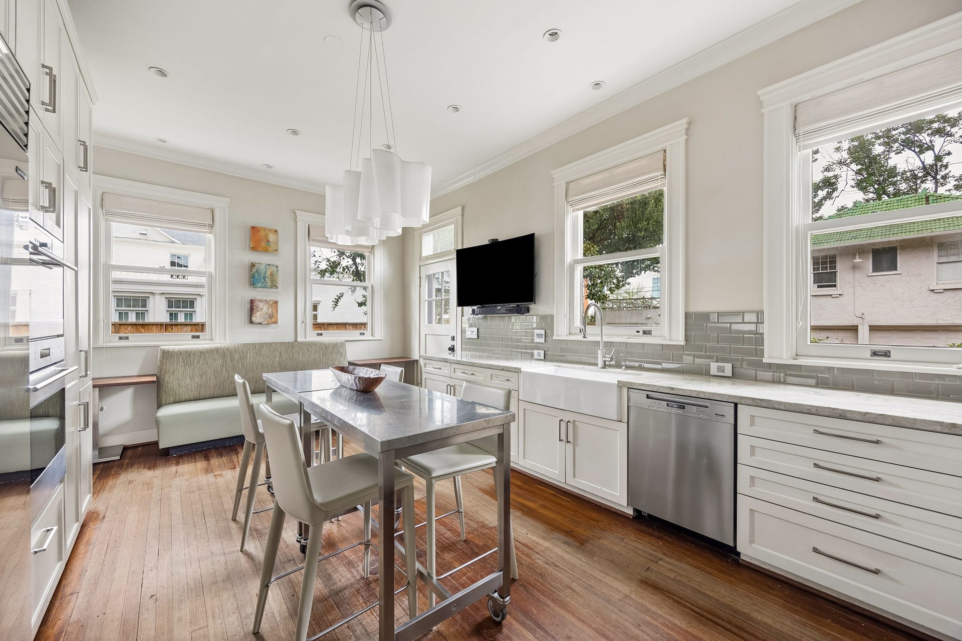 8 Courtlandt Place, Houston, TX 77006 An alternate view highlights the kitchen's quartzite countertops, charming built-in breakfast banquette and sunlit setting for casual dining.