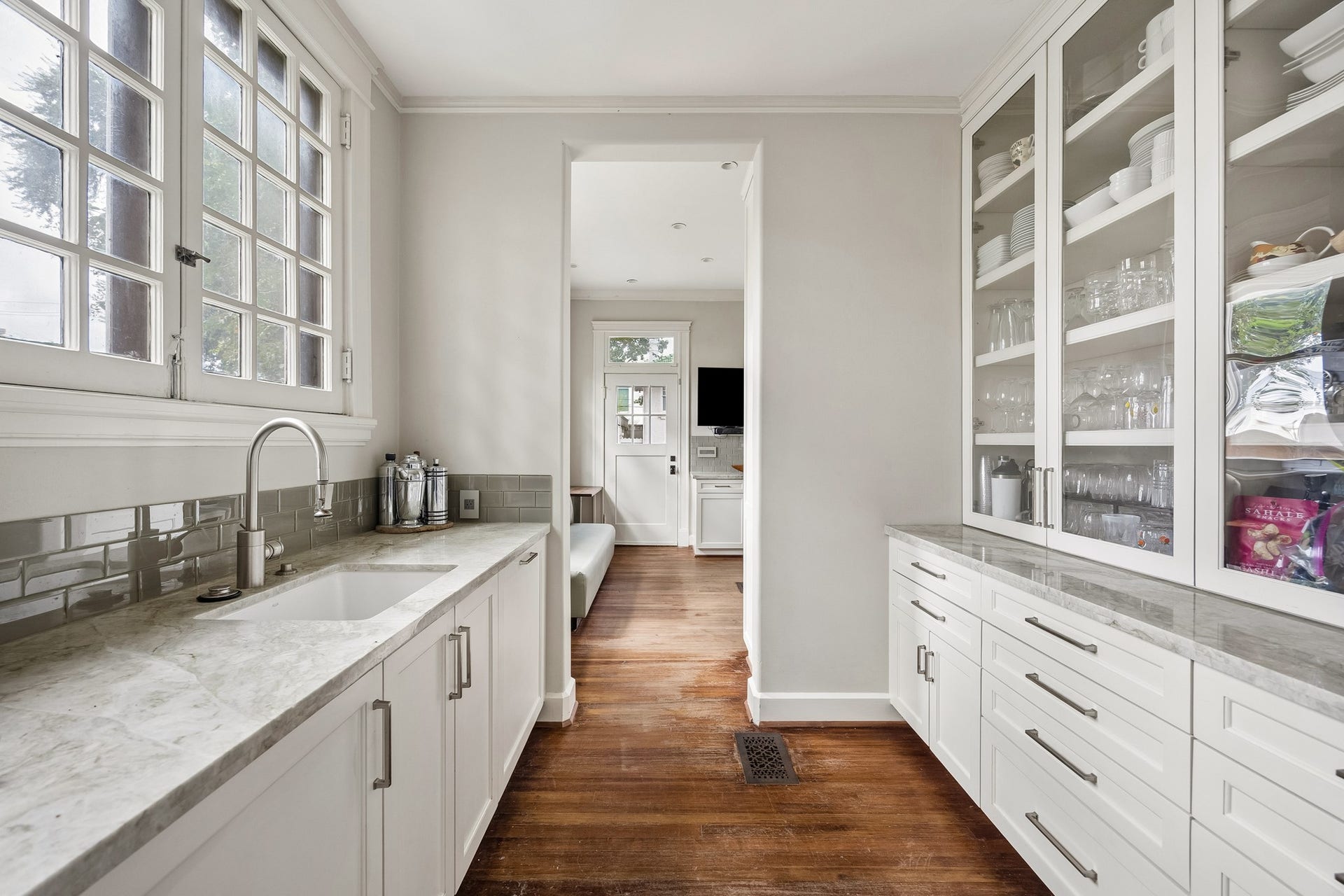 8 Courtlandt Place, Houston, TX 77006 Back inside, a thoughtfully designed butler's pantry offers quartzite countertops, glass-front cabinetry, a prep sink and extensive storage, and conveniently joins the kitchen and formal dining room.