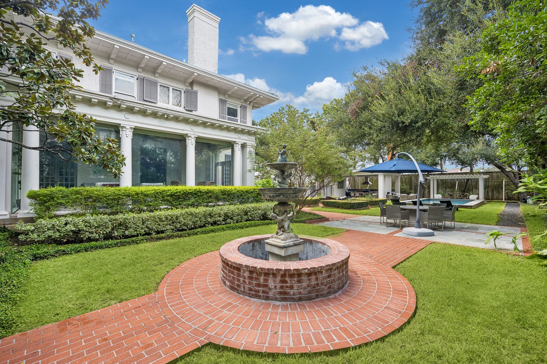 8 Courtlandt Place, Houston, TX 77006 A charming courtyard fountain anchors this picturesque garden setting, with curved brickwork, lush plantings and the home's distinctive sunroom providing a lovely backdrop.