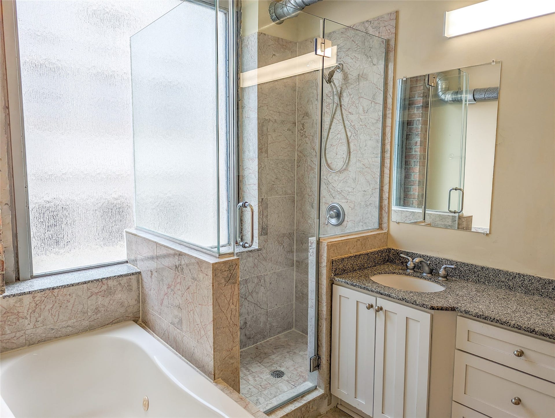 711 Main St Street, #905, Houston, TX 77002 Dual vanity sinks. Separate walk-in glass shower and bathtub. Shower has been remodeled in 2026 but is not reflected in photos due to current occupancy.