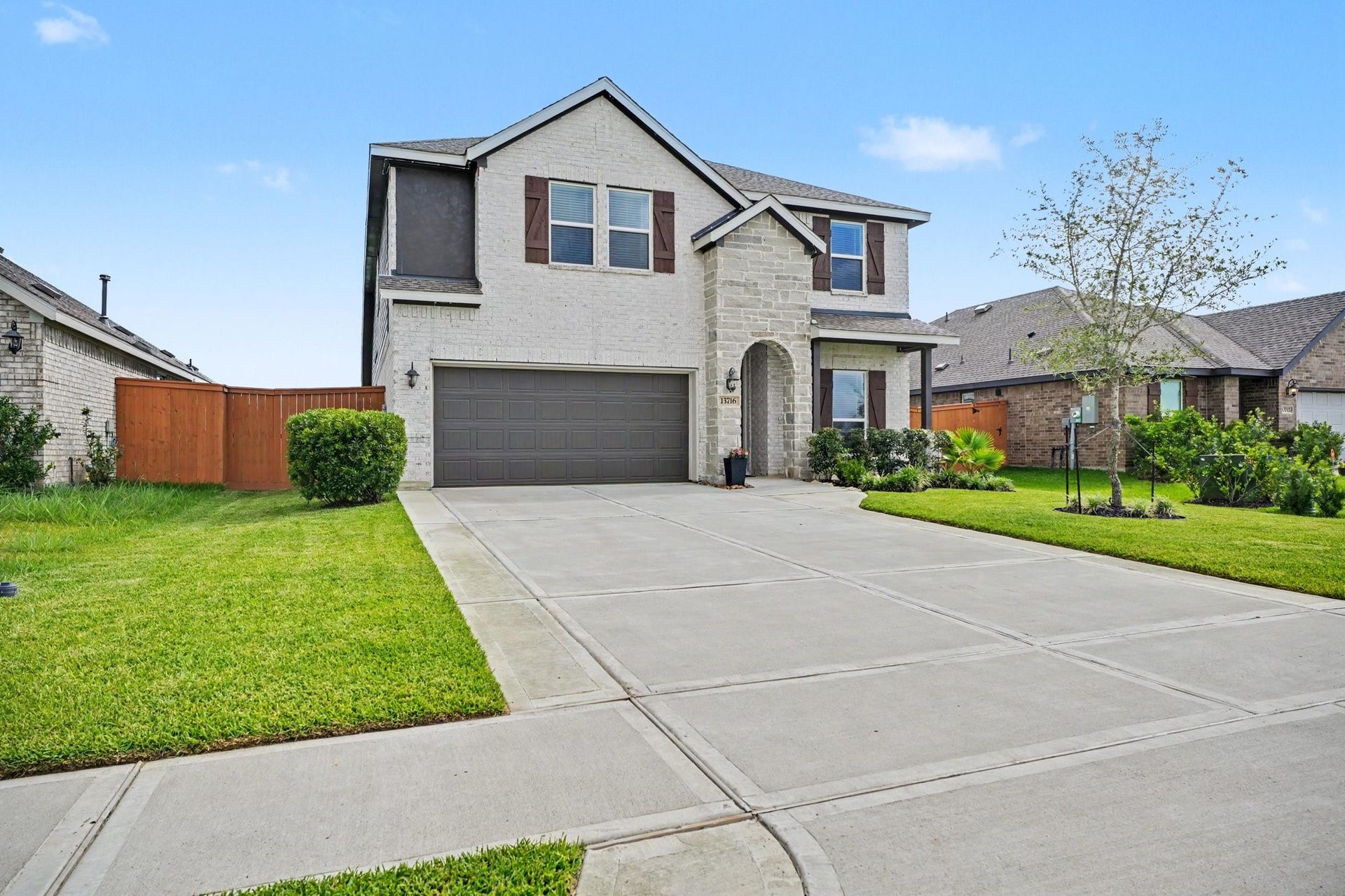 13716 Windward Mist Drive, La Marque, TX 77568 Attractive front exterior showcasing the home's modern design, oversized driveway, and well-maintained lawn.