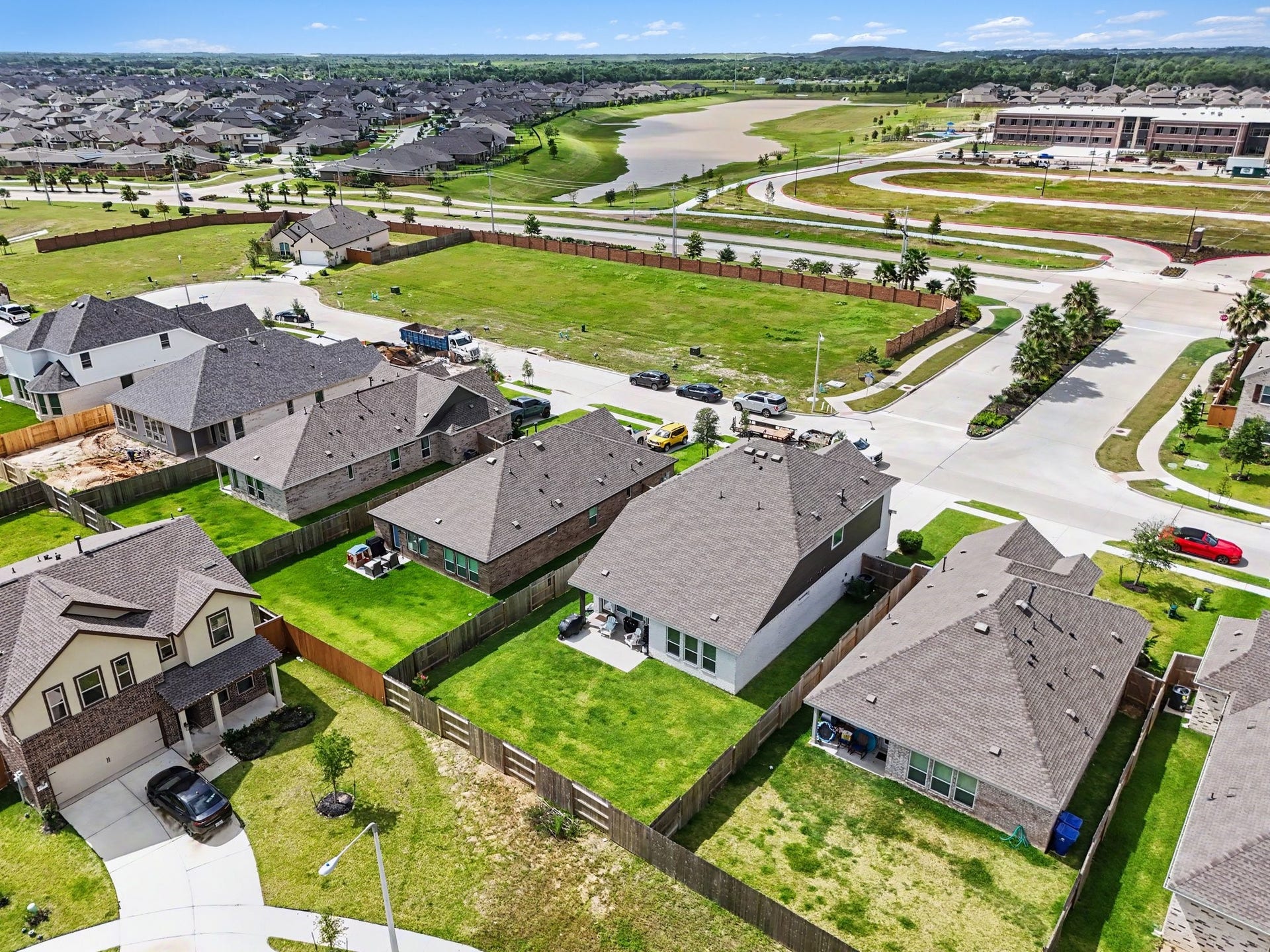 13716 Windward Mist Drive, La Marque, TX 77568 Elevated aerial perspective showcasing the spacious backyard, surrounding homes, and nearby neighborhood amenities.