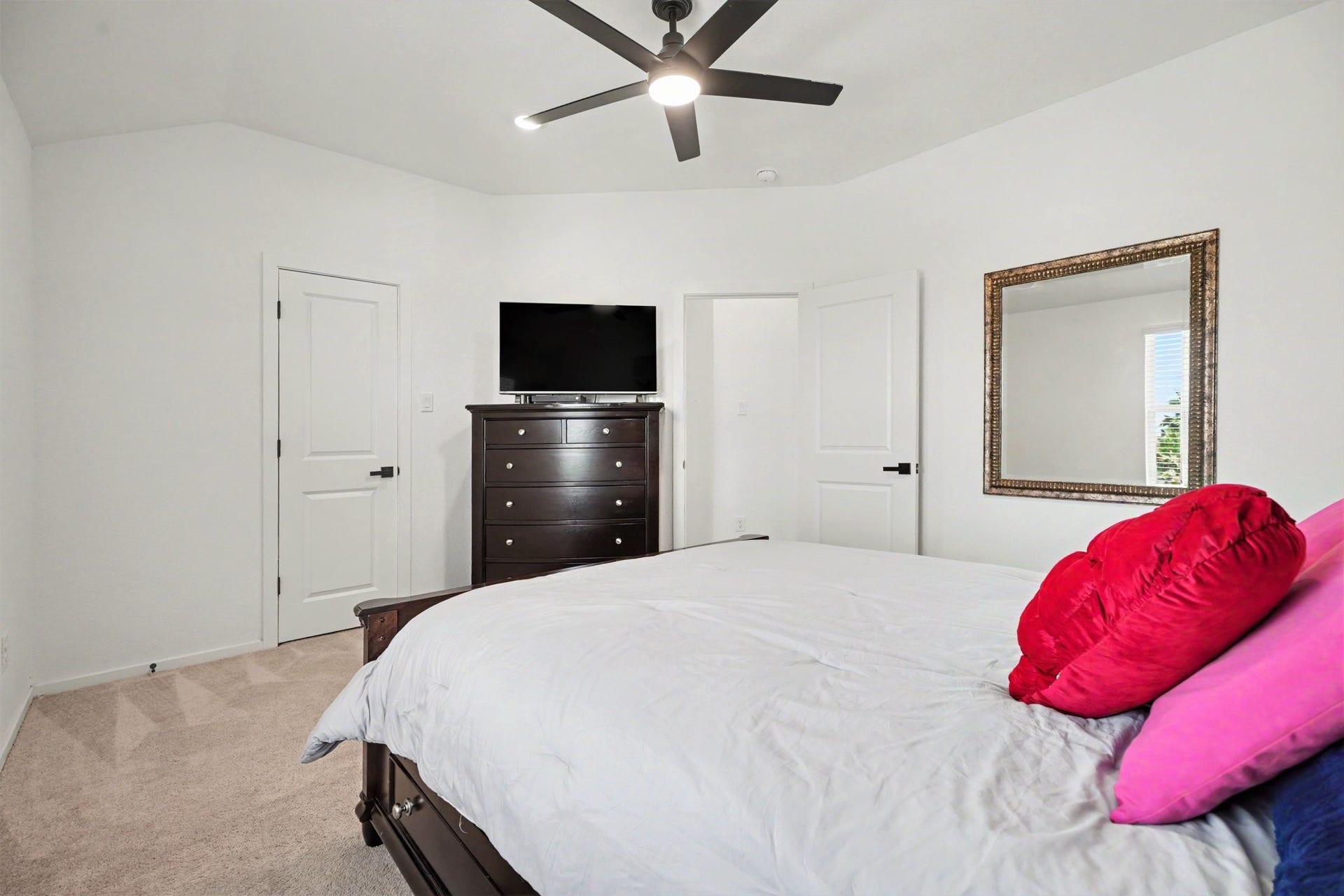 13716 Windward Mist Drive, La Marque, TX 77568 Secondary bedroom with vaulted ceilings, plush carpeting, and ample space for a variety of furniture arrangements.