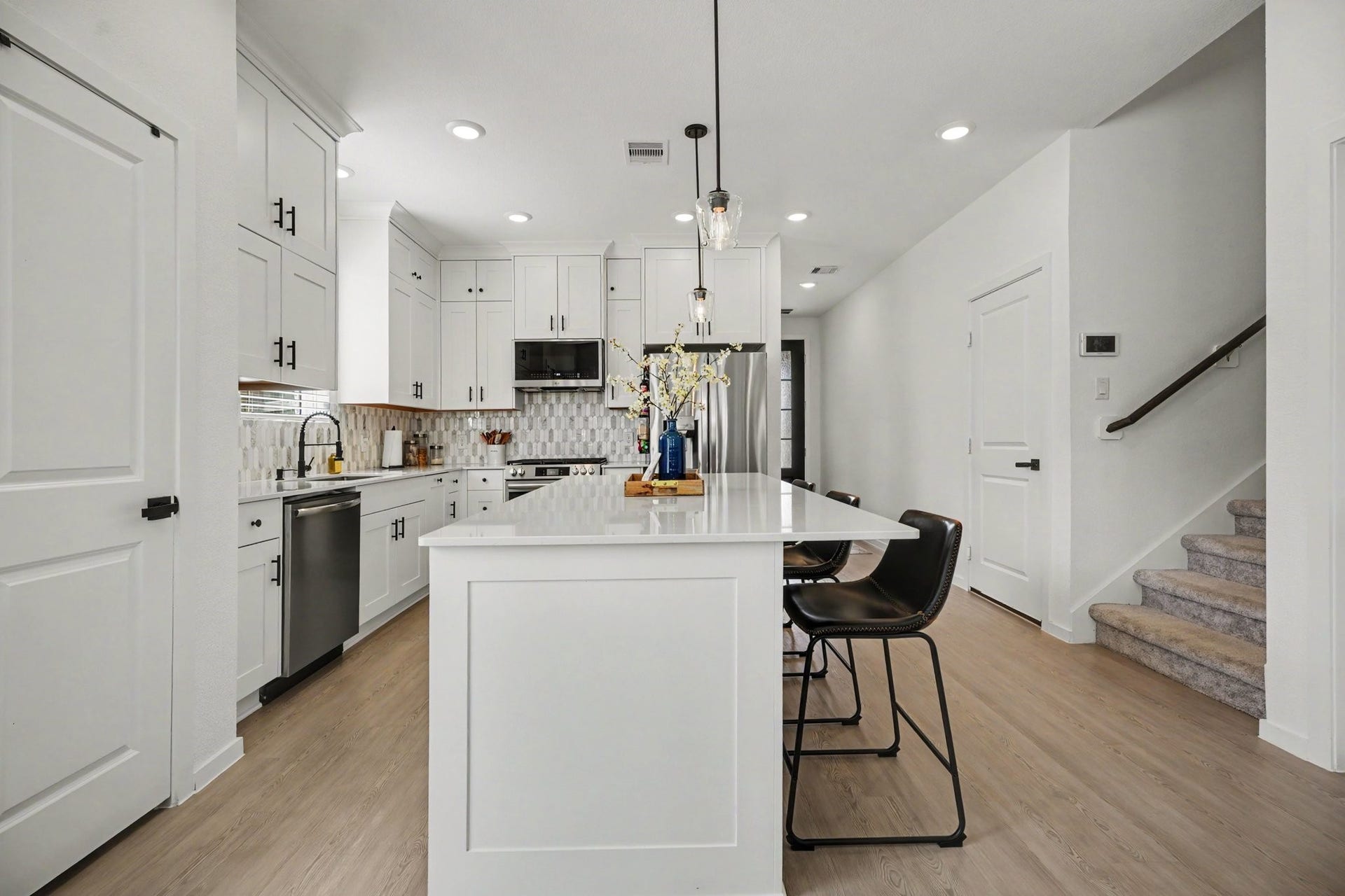 13716 Windward Mist Drive, La Marque, TX 77568 Expansive kitchen featuring a large center island with seating, abundant cabinetry, and custom sliding lower cabinet drawers that provide ample storage and easy access to everyday essentials.
