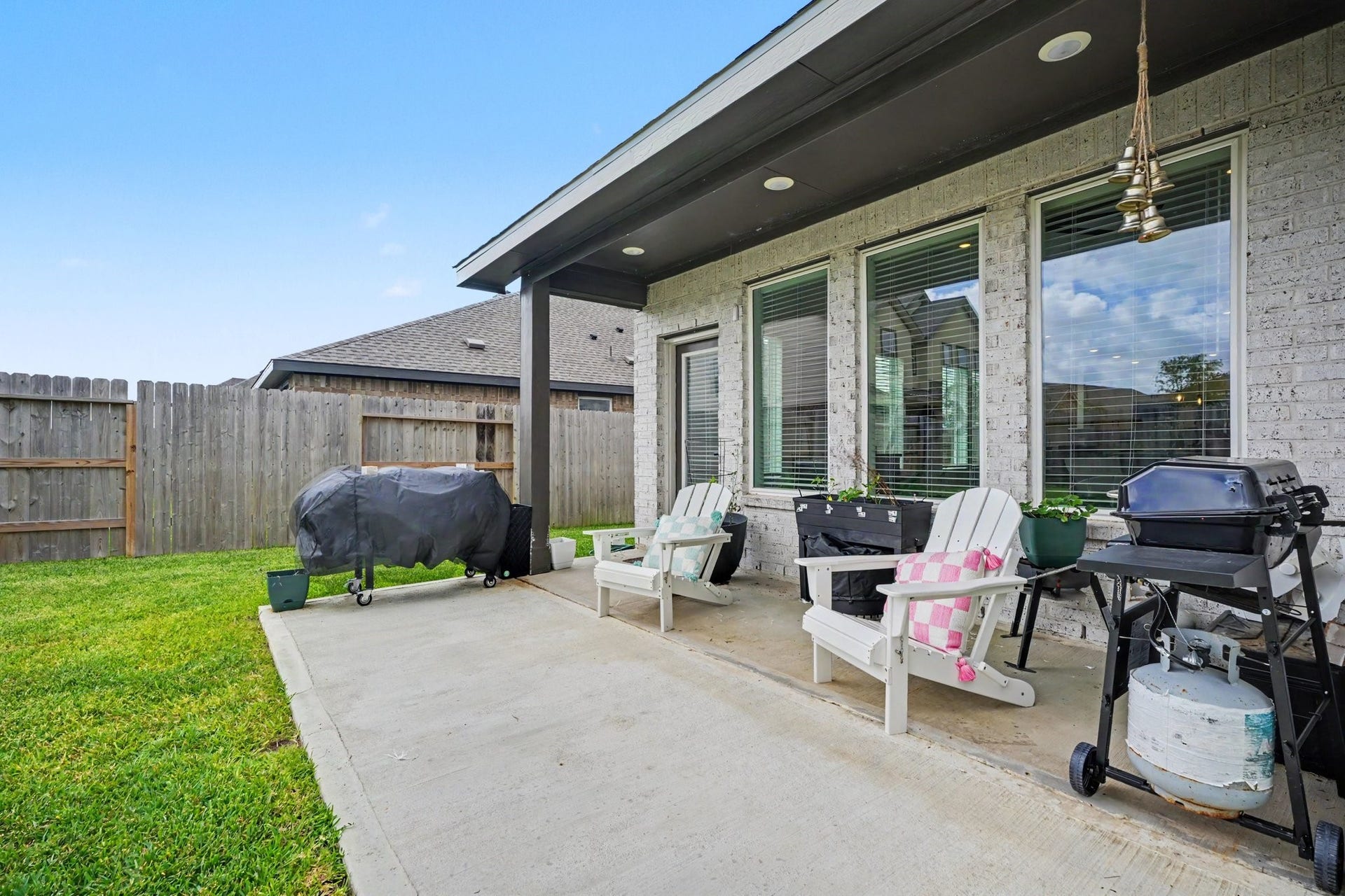 13716 Windward Mist Drive, La Marque, TX 77568 Covered patio with space for outdoor seating and grilling, creating a comfortable spot to enjoy the backyard.