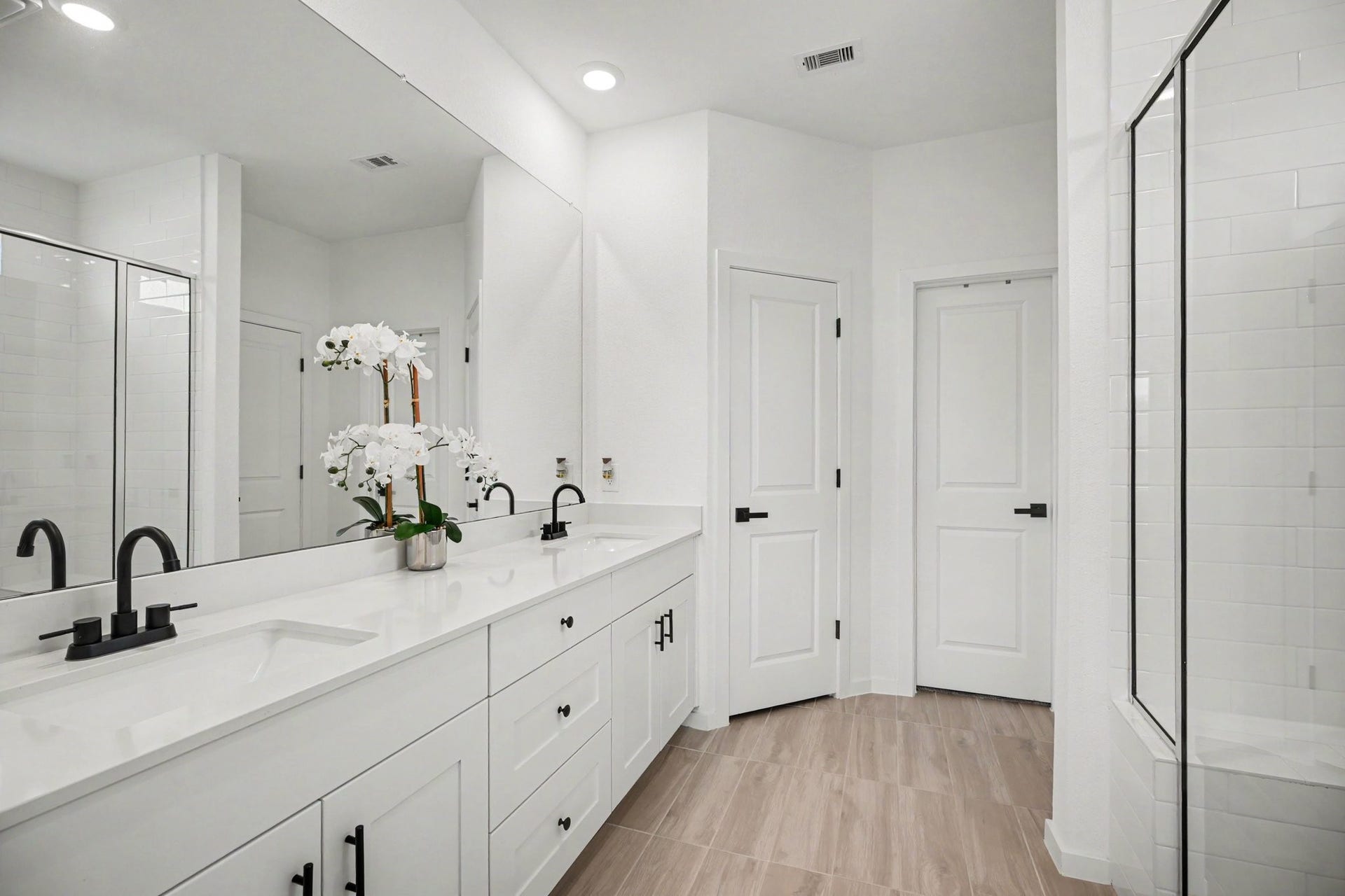 13716 Windward Mist Drive, La Marque, TX 77568 Well-appointed primary bath featuring a dual-sink vanity, expansive mirror, abundant cabinet and drawer storage, and a dedicated linen closet.