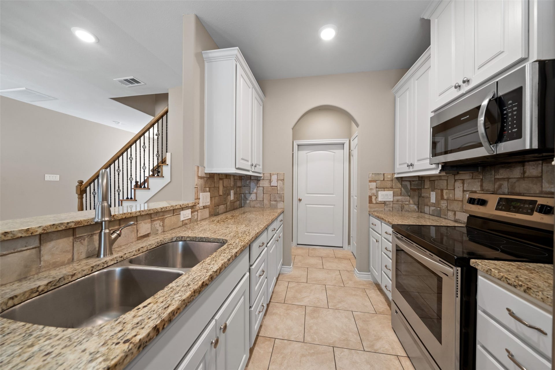 Closer look inside the kitchen. Door in the background leads to the private garage. Kitchens of each unit are identical.