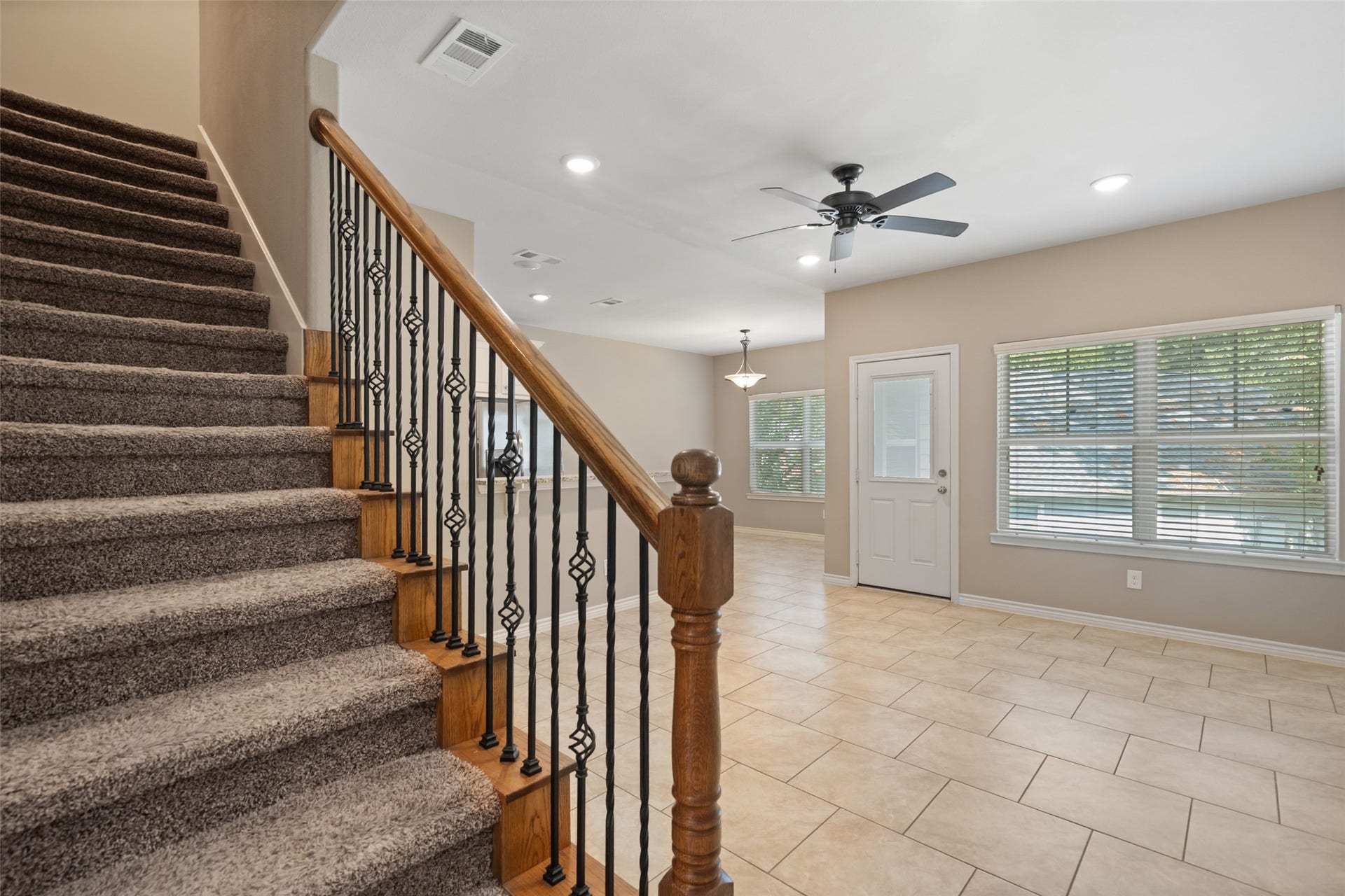 Nice staircase with decorative wrought iron railing, and stained oak banister.