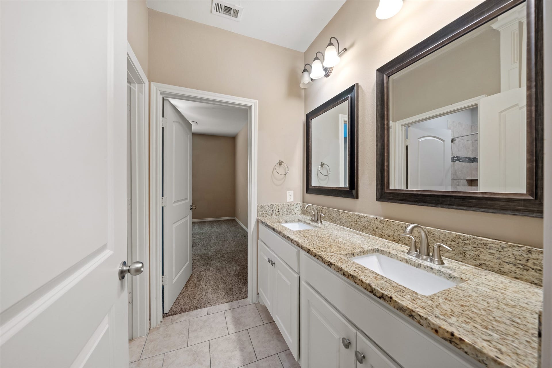 Full bath has two vanities with ample storage.