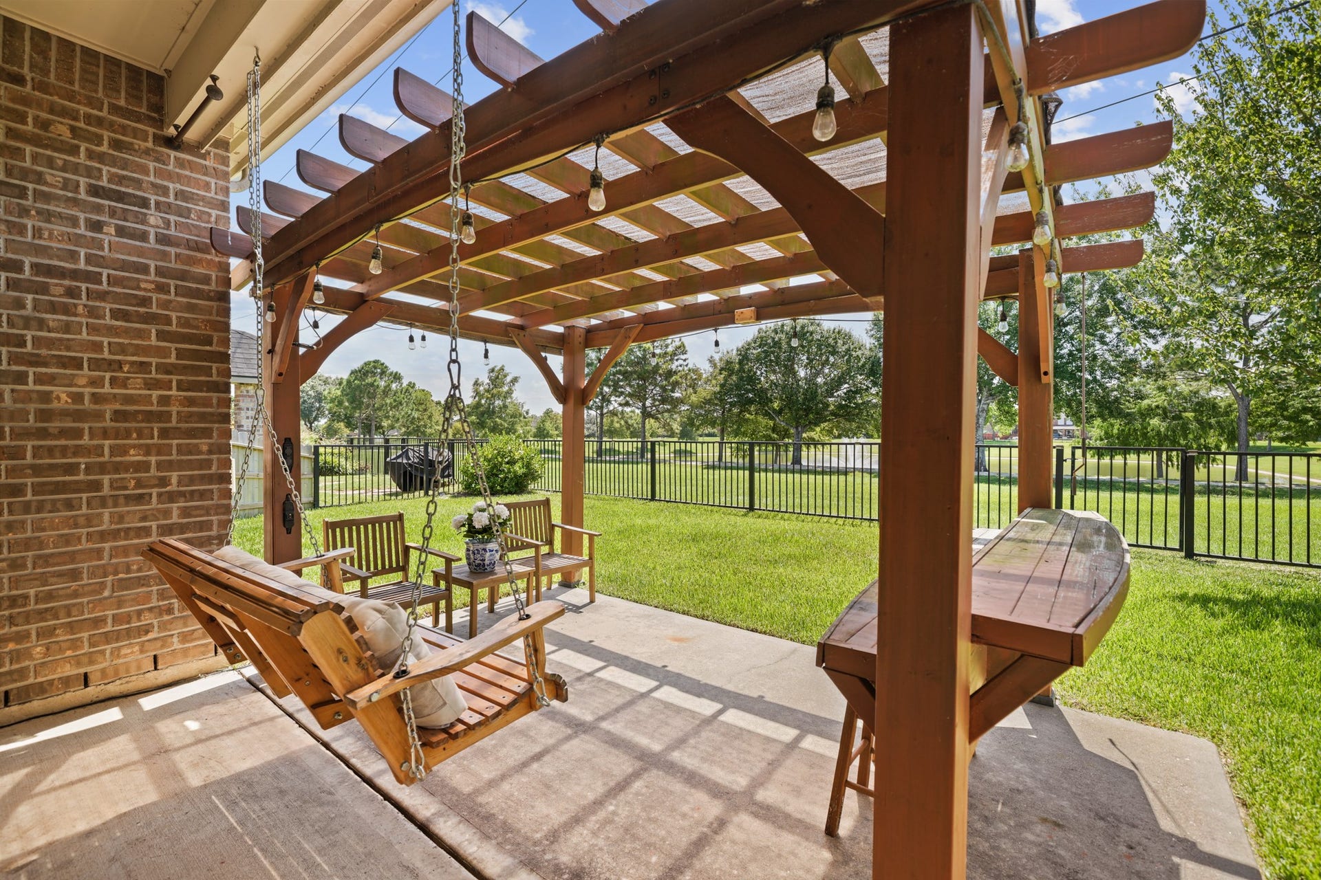 2634 Night Song Drive, Pearland, TX 77584 Enjoy outdoor living beneath the custom pergola complete with swing seating, bar area, and space for entertaining.