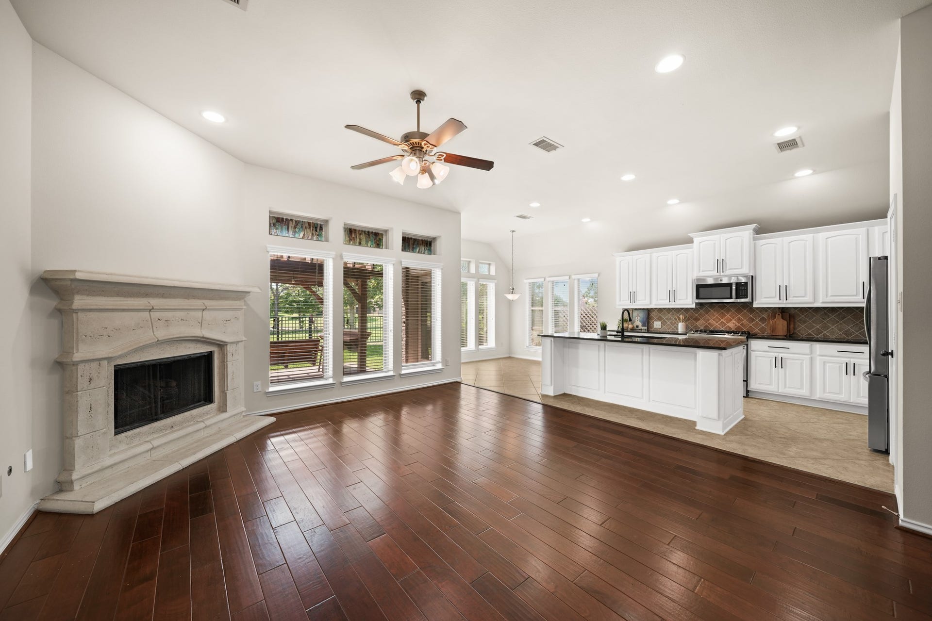 2634 Night Song Drive, Pearland, TX 77584 Spacious family room with hardwood flooring, elegant stone fireplace, and an open-concept layout.