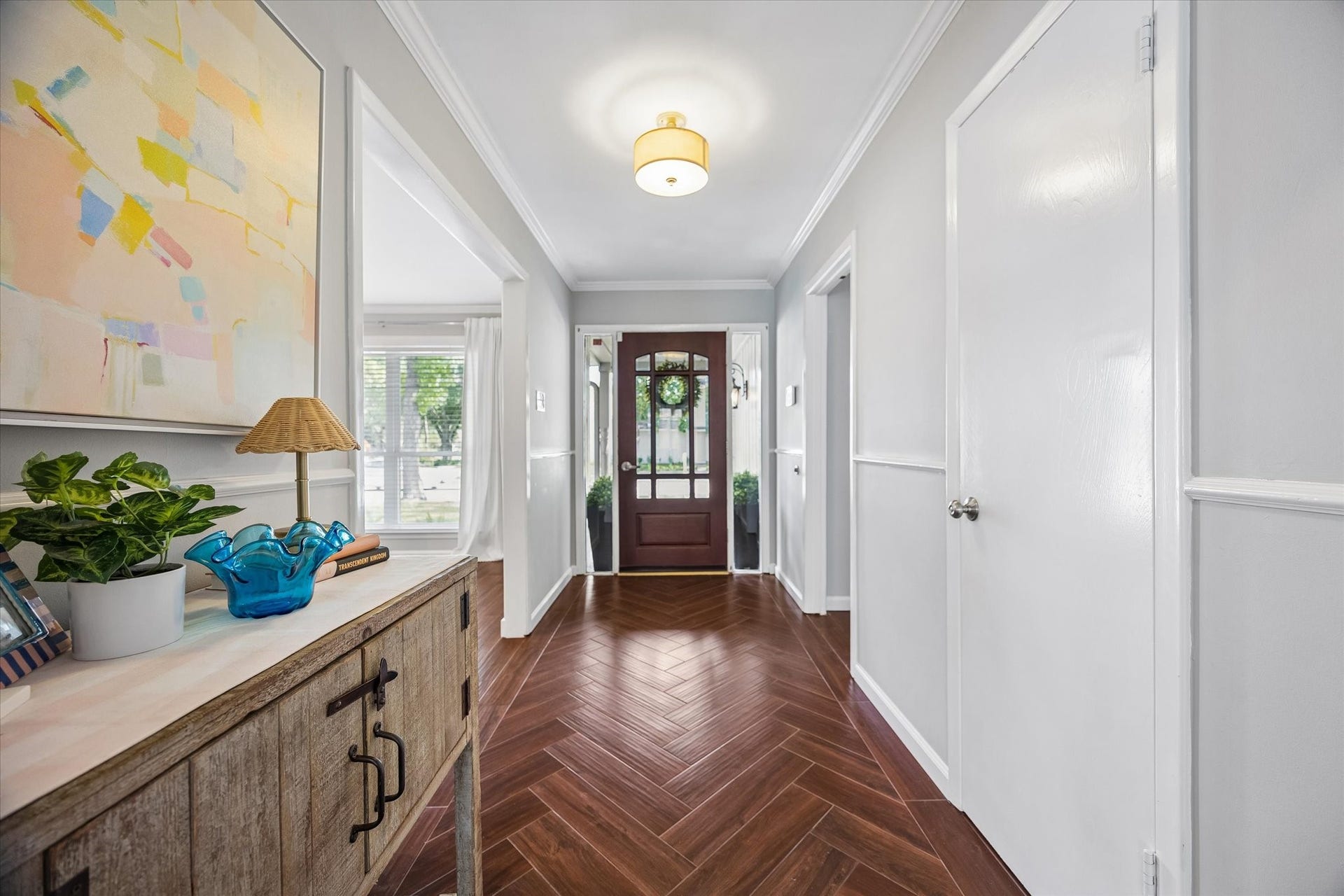 At the front of the home, youre greeted by a stunning entryway that sets a sophisticated tone with herringbone-patterned tile flooring and crown molding.