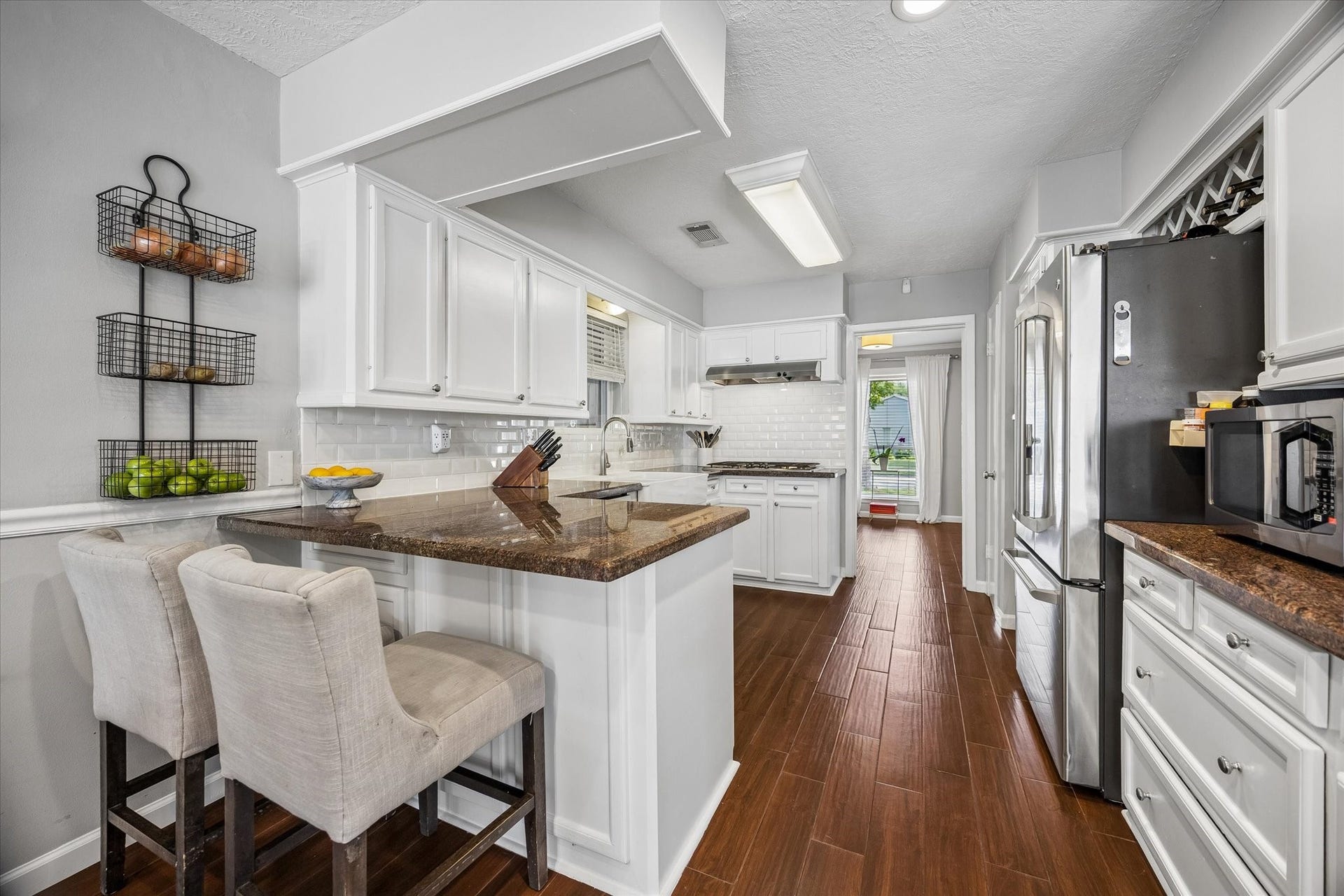Kitchen boasts tons of storage, recessed lighting, gas stove top, beveled subway tile backsplash, and plenty of prep and storage space.