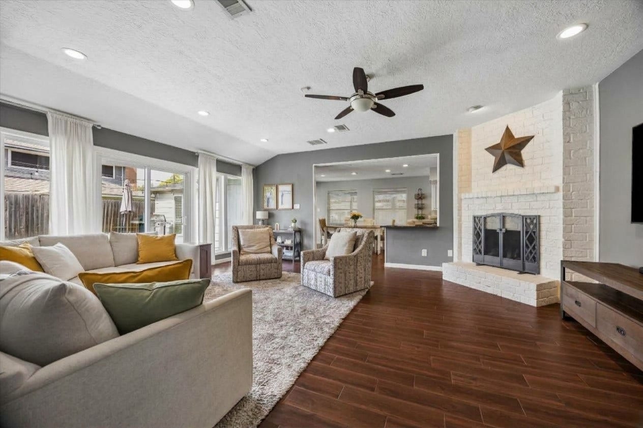 Soaring ceilings and recessed lighting create a bright, airy flow that leads directly into the modern kitchen. Sliding glass doors offer a seamless transition to the deck and backyard, perfect for effortless indoor-outdoor living.