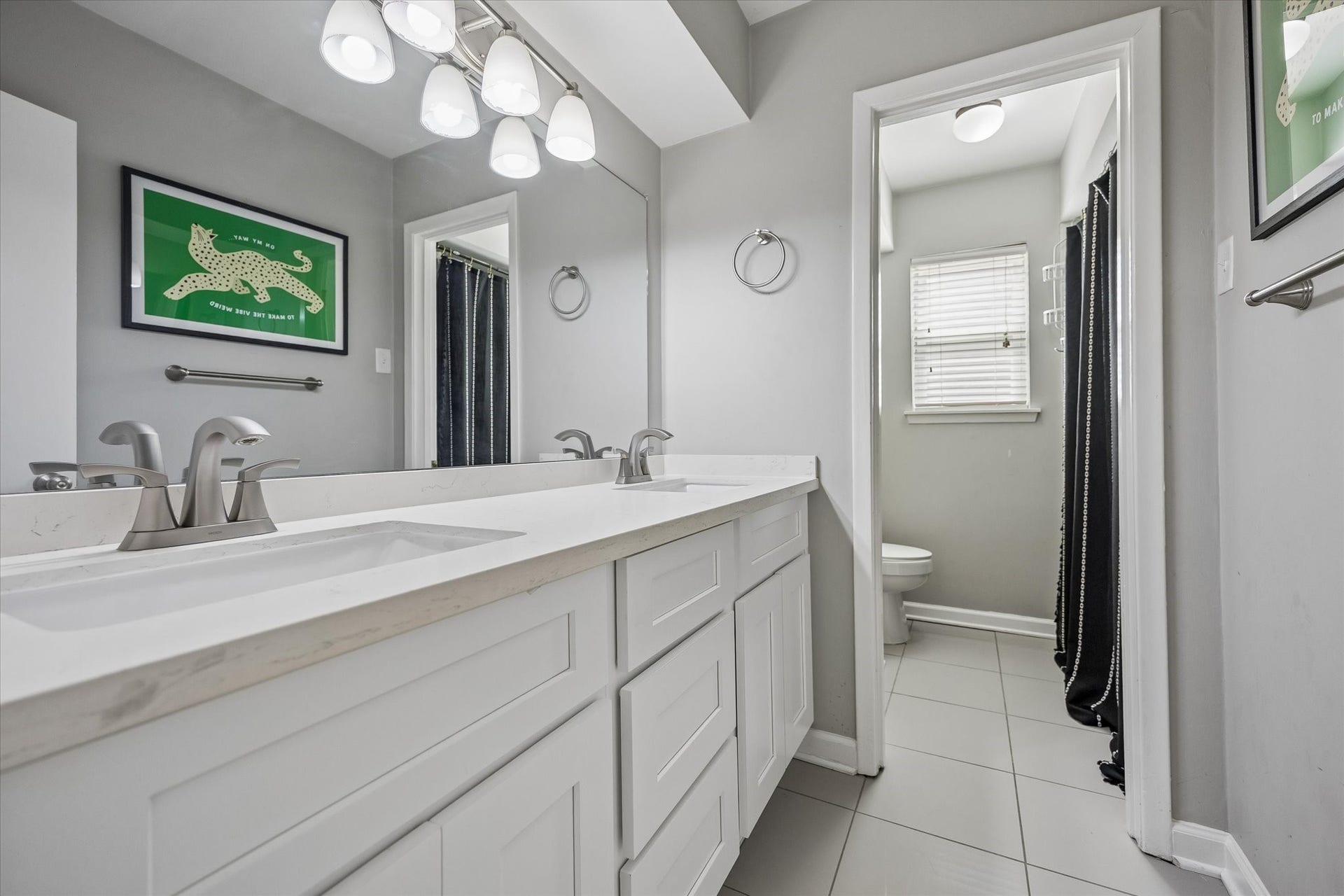 Updated guest bath with convenient double sinks and tub/shower combo.