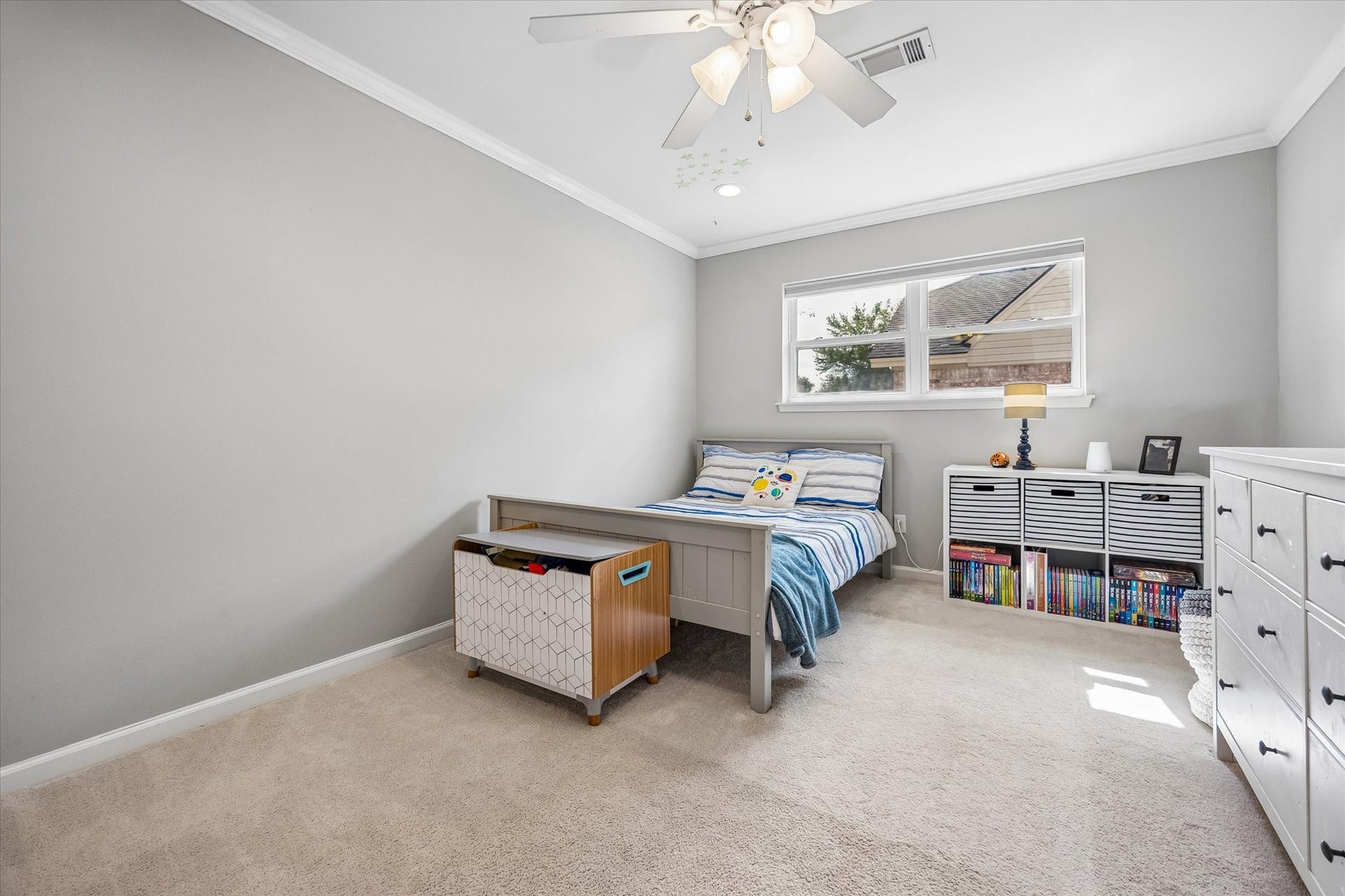 Another guest bedroom featuring crown molding and two closets.