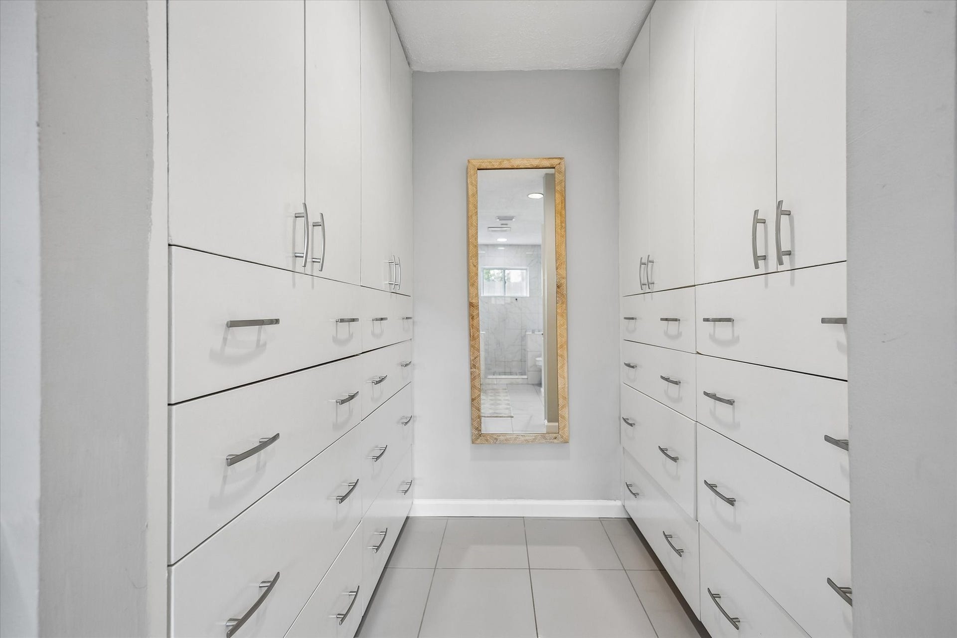 The primary bath is thoughtfully designed for effortless organization, featuring an abundance of additional drawers and cabinet space to keep all your toiletries and everyday essentials neatly tucked away.