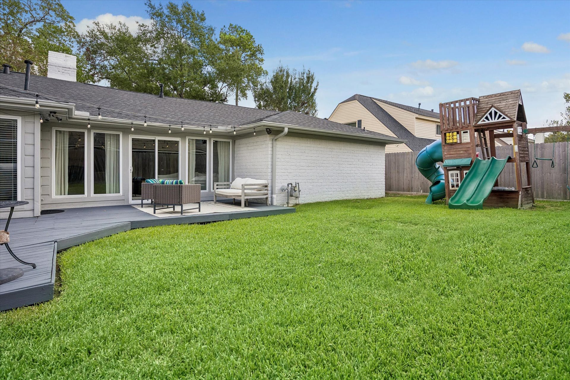 Step out onto this expansive deck, a space designed for effortless indoor-outdoor living. Large sliding glass doors create a seamless connection between the fresh air and the inviting interior living space, making it easy to host gatherings.
