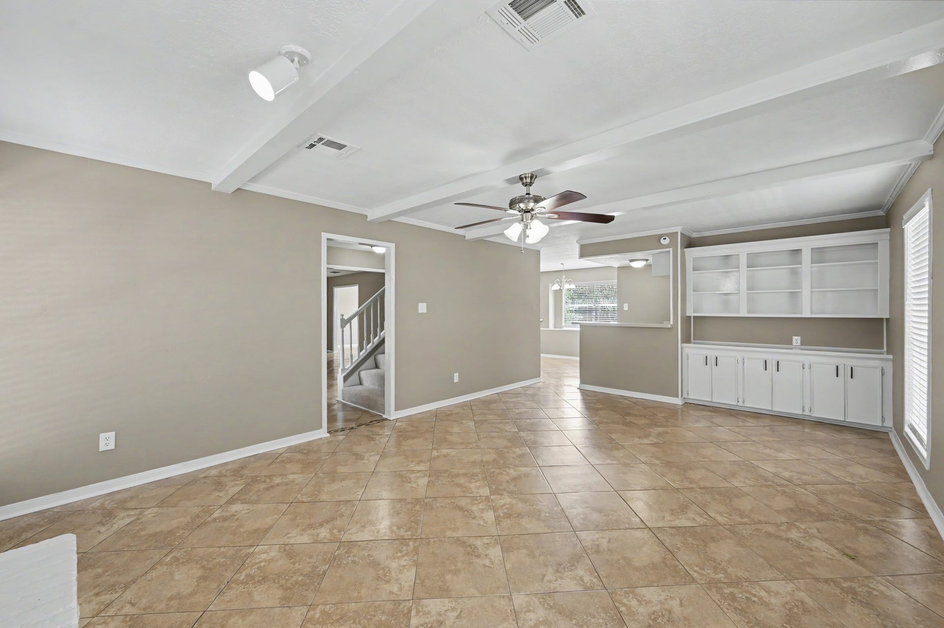 A spacious gathering spot with charming ceiling beams and built-in shelving for all your favorite things.
