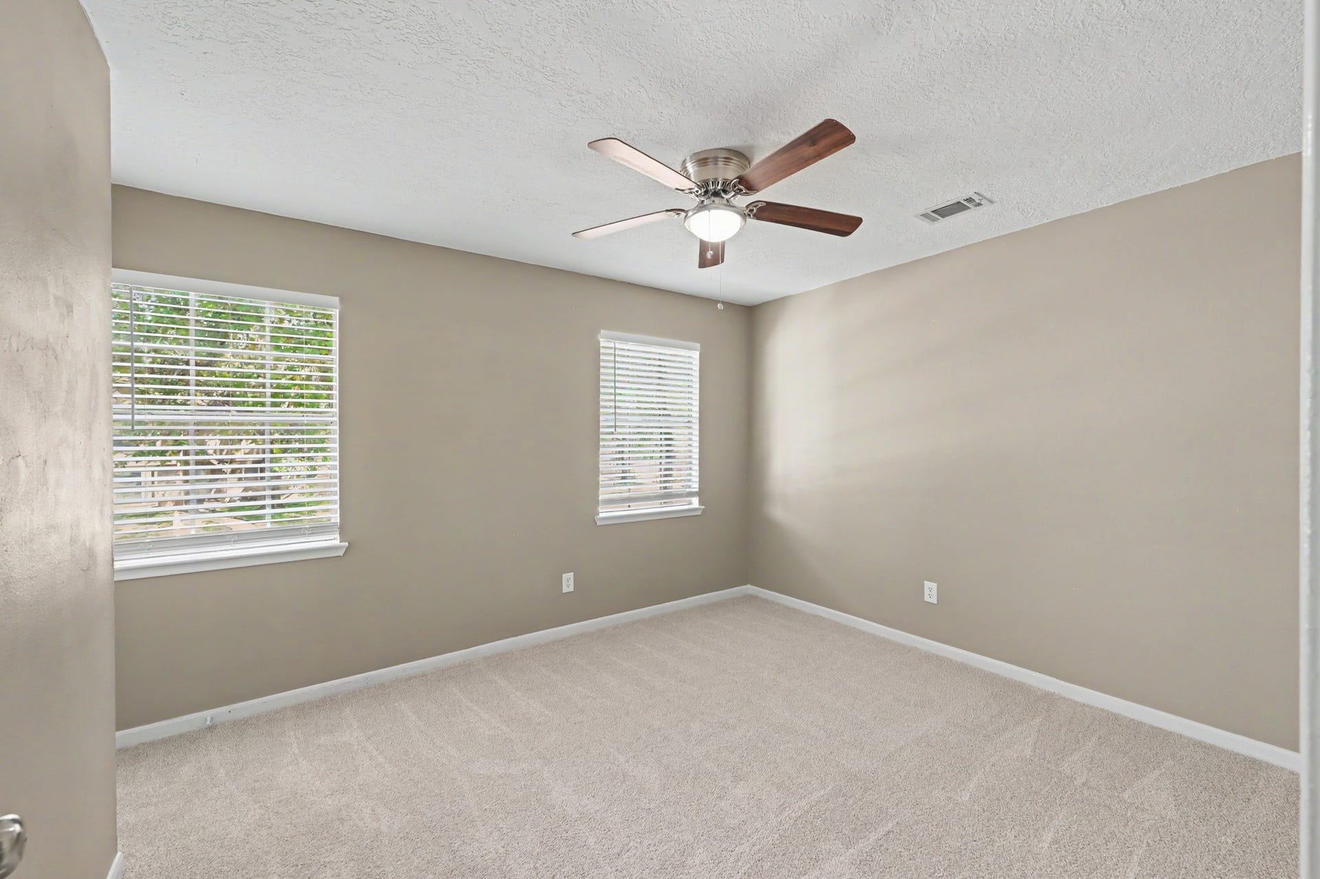 Bright and ready to make your own, with fresh carpet and a ceiling fan for added comfort.
