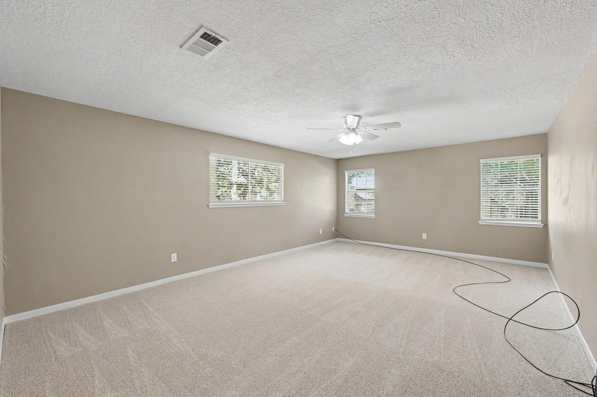 Room to spread out and unwind! This oversized primary suite offers fresh carpet and windows galore.