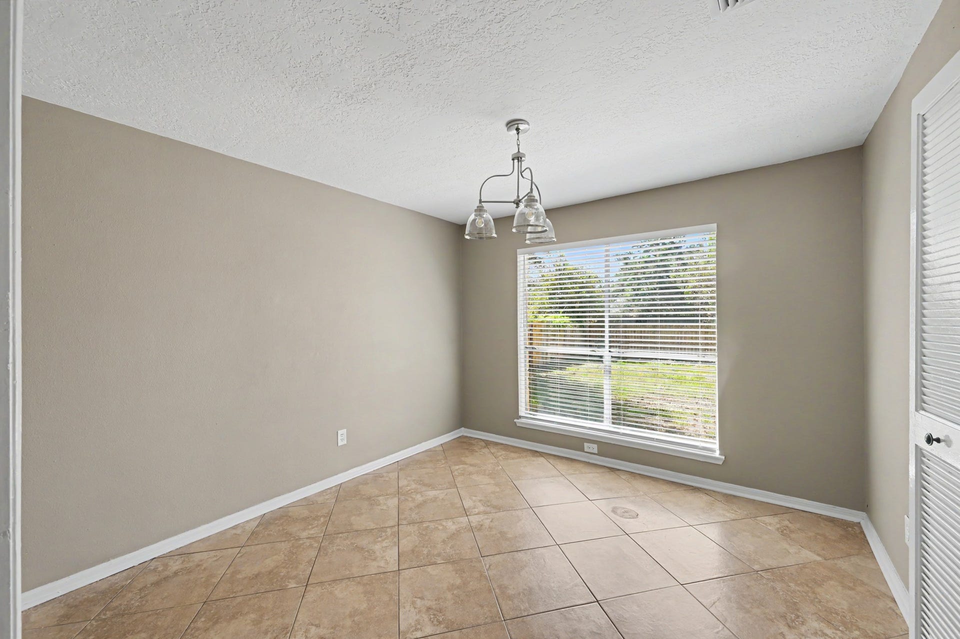 Bright and inviting dining space with a large window and plenty of natural light.