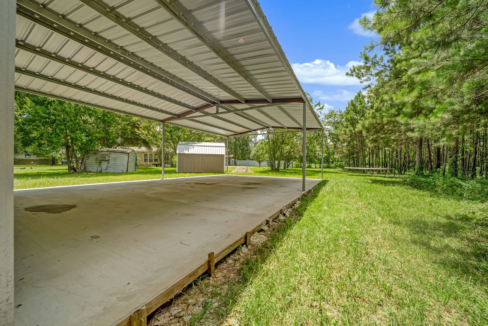 The open bay offers exceptional versatility, providing the perfect space to park RVs, boats, trailers, equipment, or create a covered workspace for projects and outdoor hobbies.