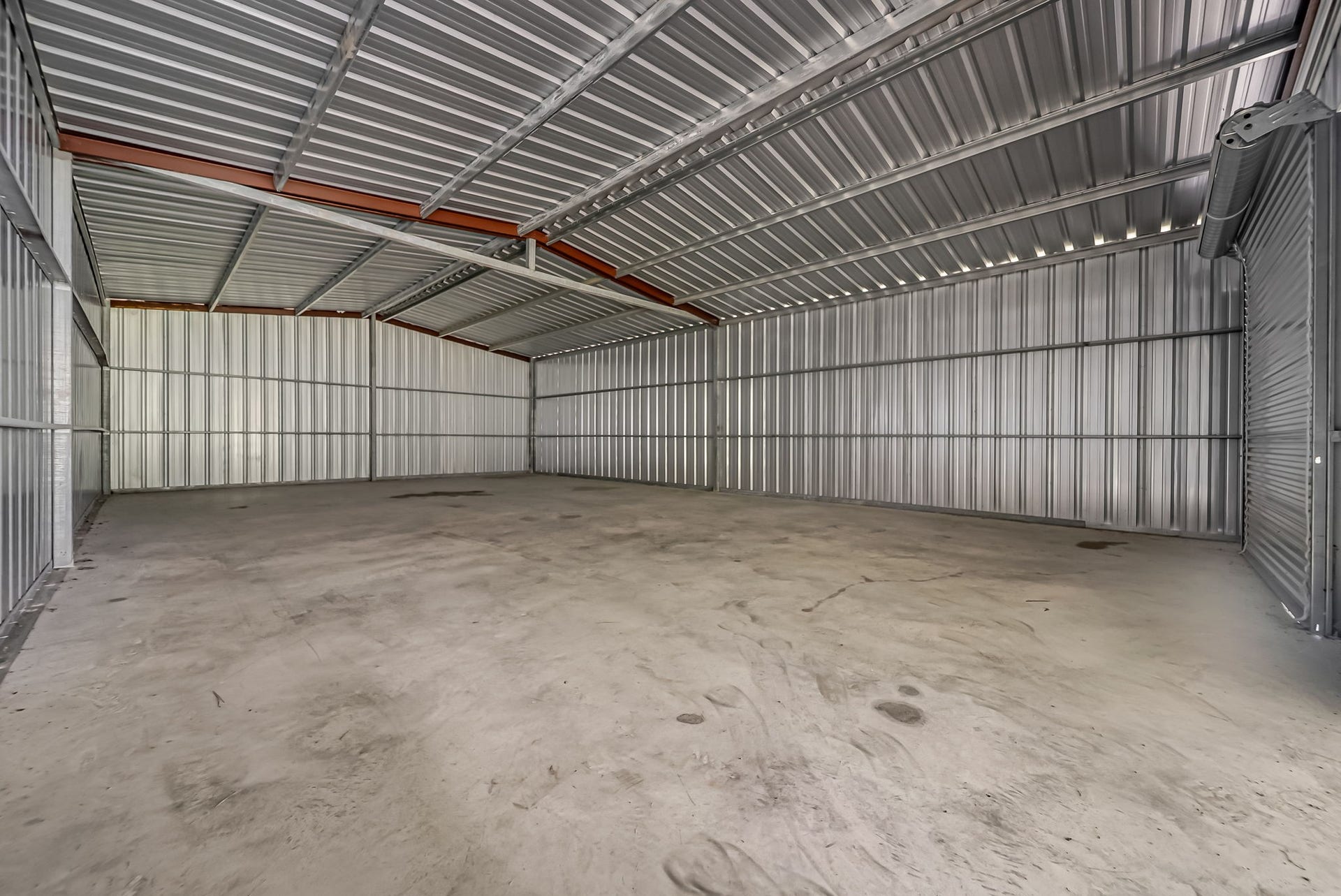 A true standout feature, the approximately 1,500-square-foot enclosed workshop combines an open-concept layout, continuous concrete slab, high-clearance ceilings, and two roll-up doors.