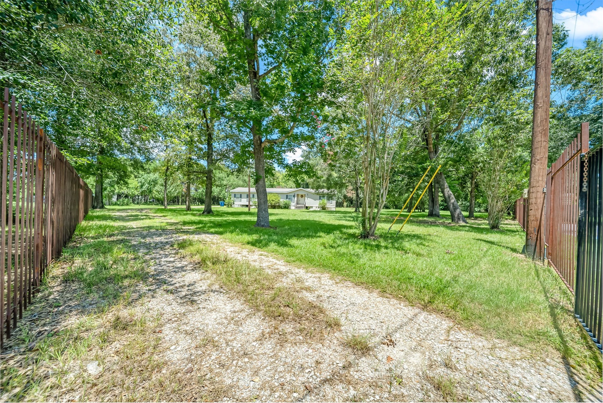 A metal fence and gated entrance welcome you onto the property, offering enhanced privacy, security, and a picturesque approach.