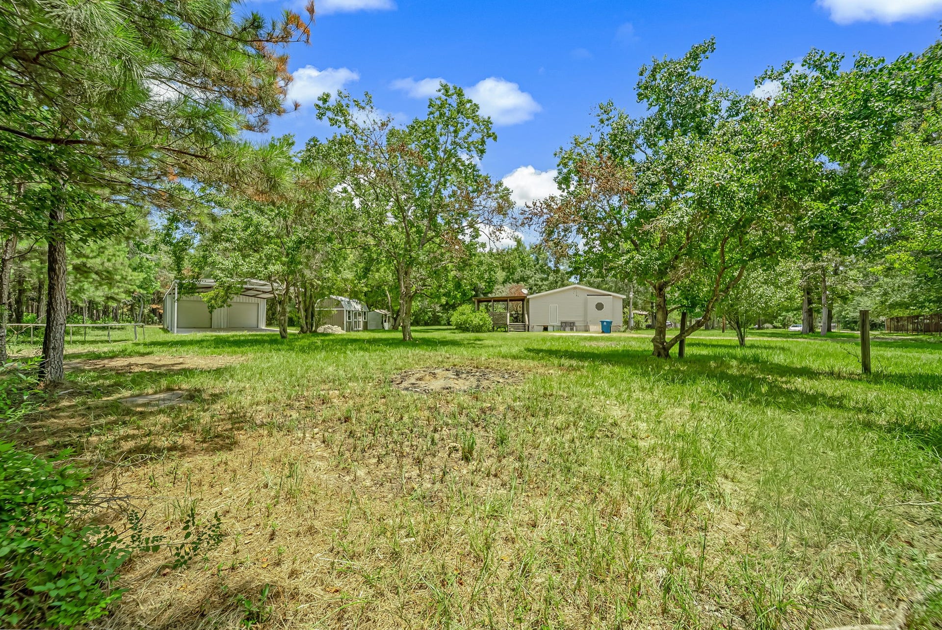 Enjoy the flexibility of country living with a spacious homesite that offers a manufactured home, storage shed, and oversized metal building, while still providing plenty of room to grow, entertain, or create your ideal outdoor space.