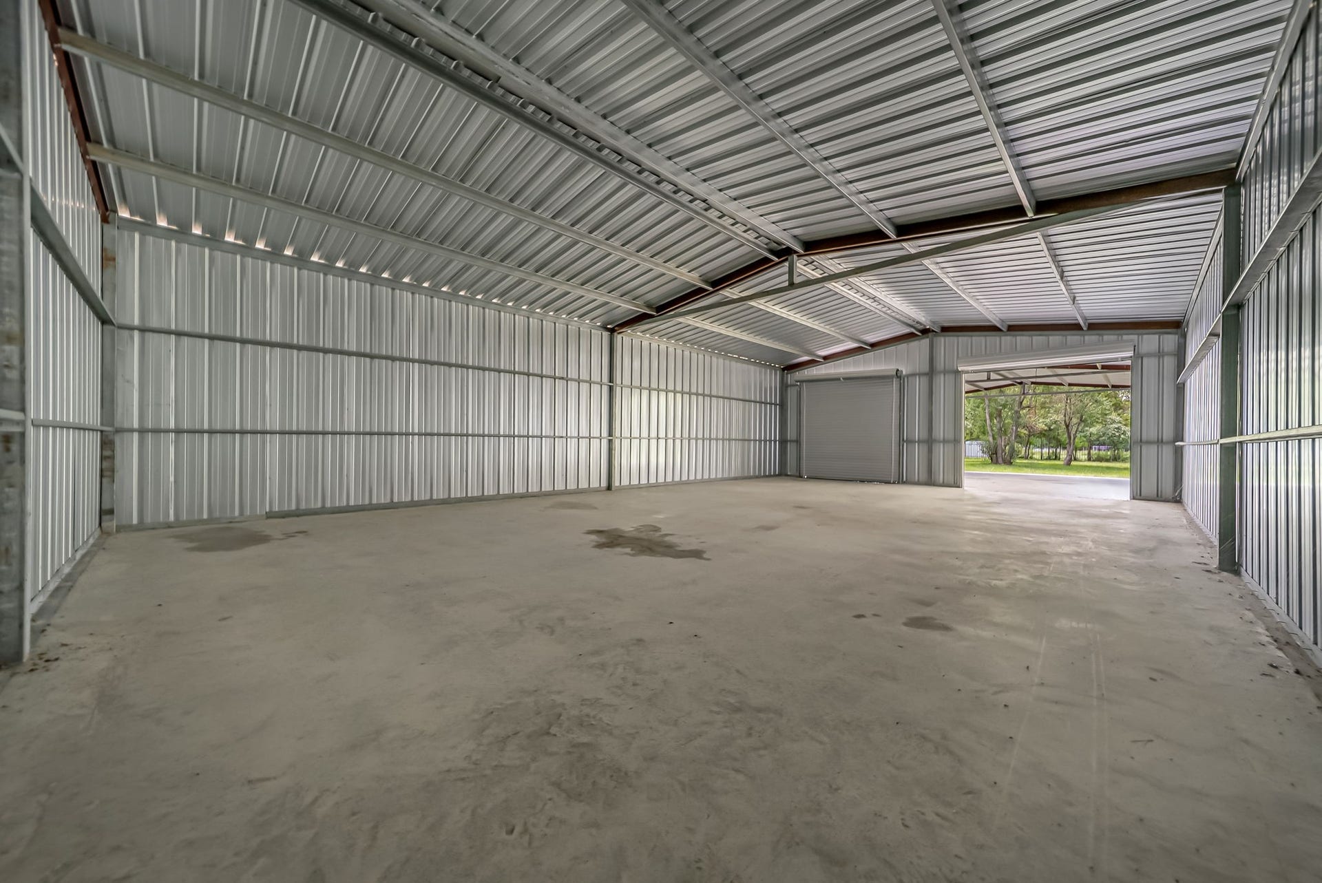The fully enclosed 30' x 50' workshop offers exceptional space for equipment, vehicles, hobbies, or a home business, complete with two roll-up doors and a continuous concrete slab for added functionality.