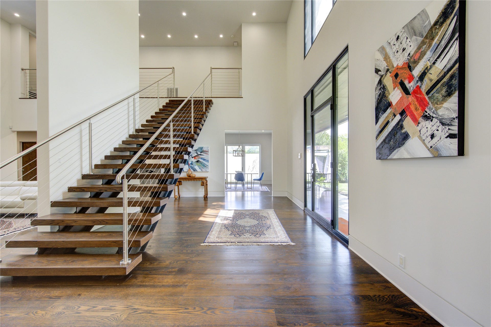 5202 Chesapeake Way, Houston, TX 77056 This modern home features an open, airy foyer with high ceilings and a sleek floating staircase. Large windows provide plenty of natural light, while contemporary artwork and hardwood floors add elegance.