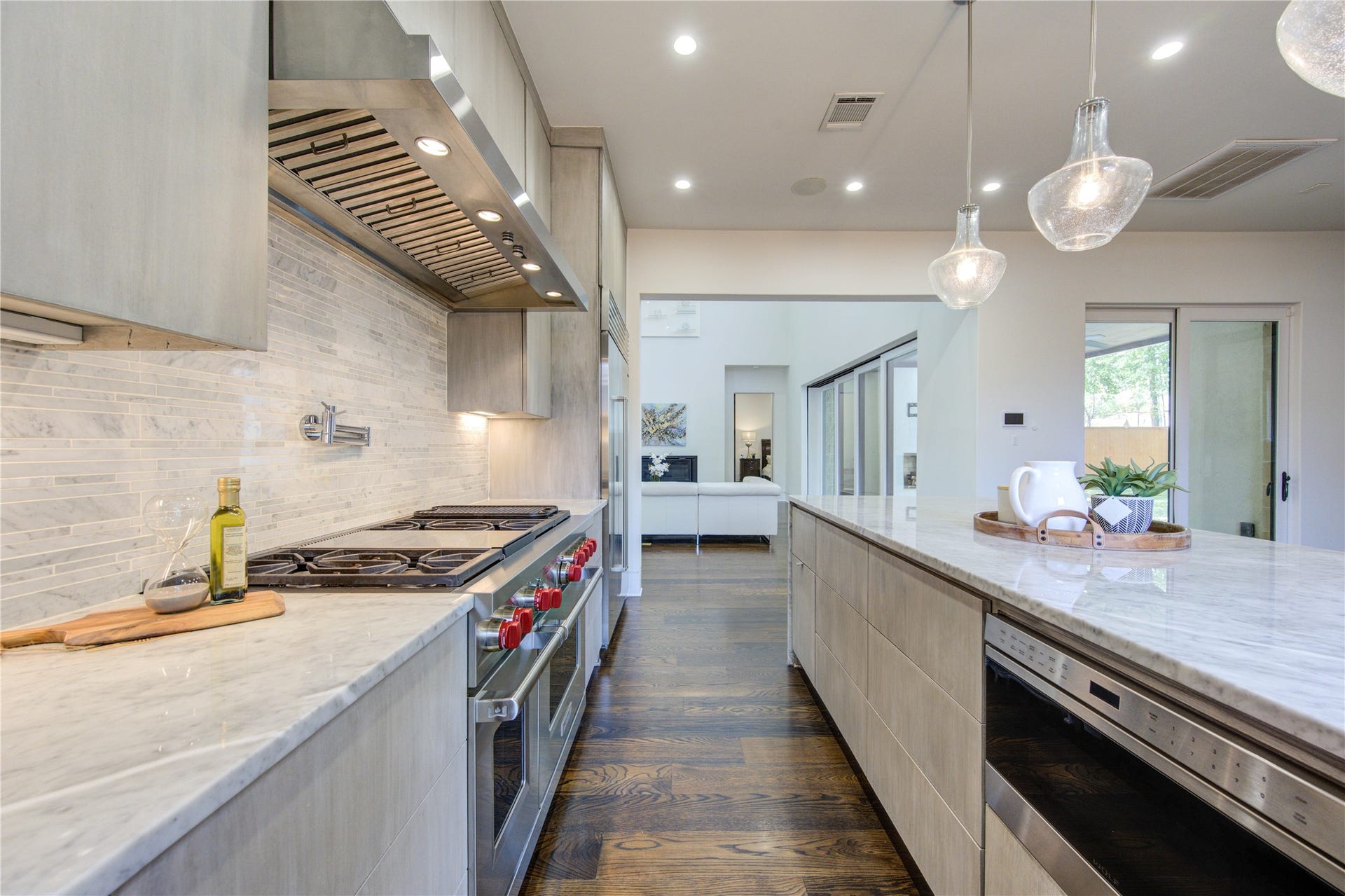 5202 Chesapeake Way, Houston, TX 77056 The modern kitchen boasts sleek stainless steel appliances, a spacious marble-topped island, elegant pendant lighting, and a stylish tile backsplash, offering a perfect blend of functionality and contemporary design.