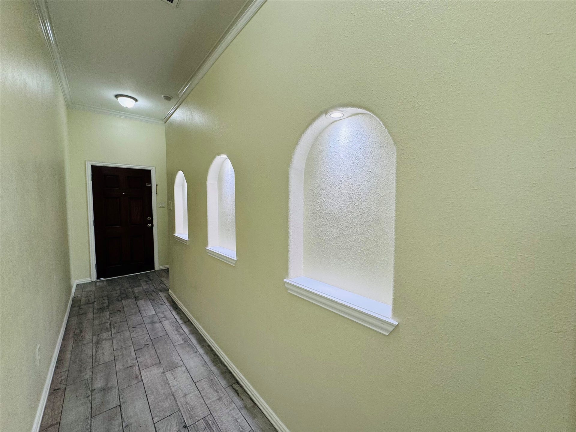 Inviting hallway with elegant arched niches, warm lighting.