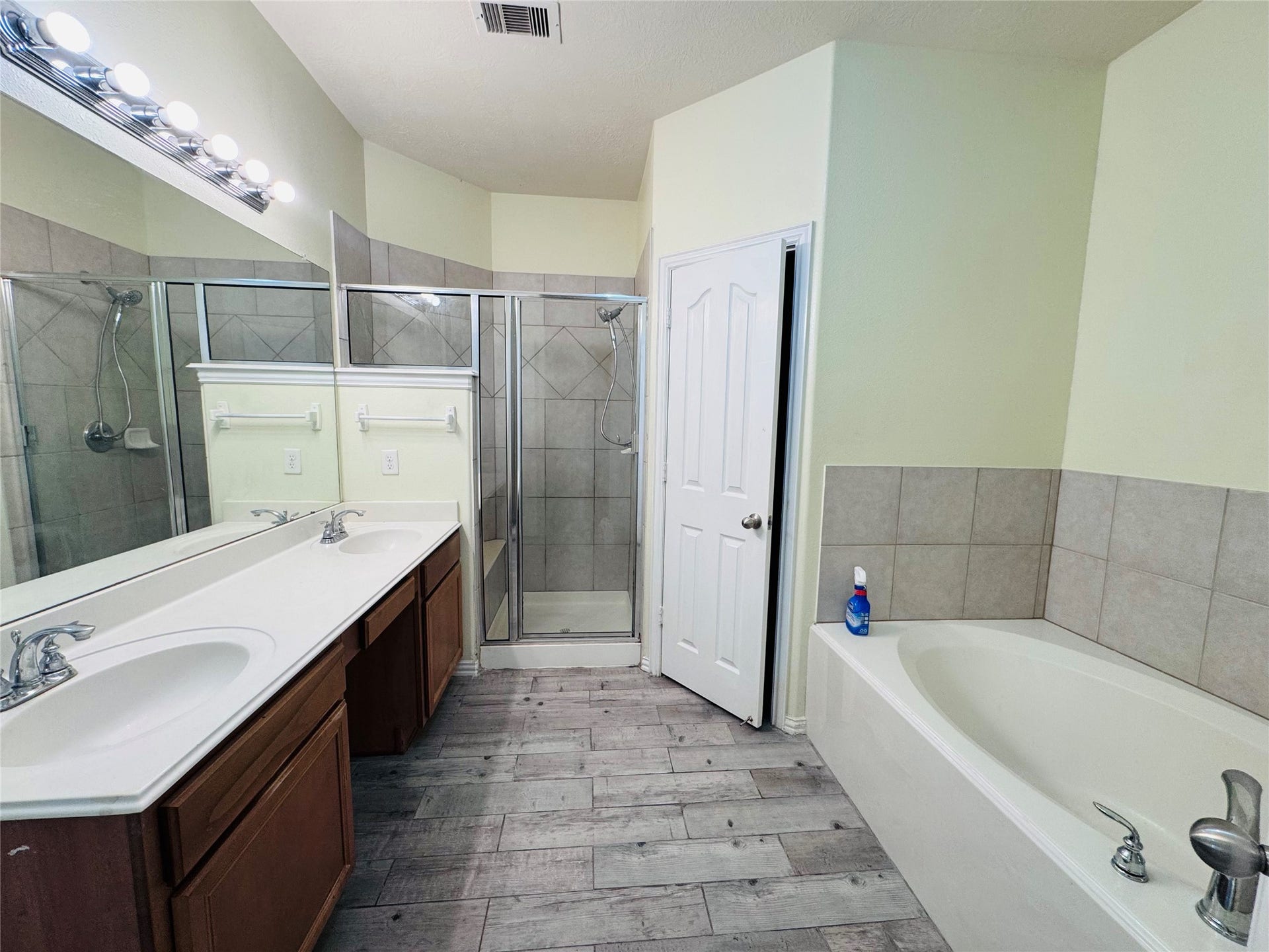 Experience the elegance of this primary bathroom, featuring a spacious dual-sink vanity, a sleek glass shower, and a luxurious soaking tub.