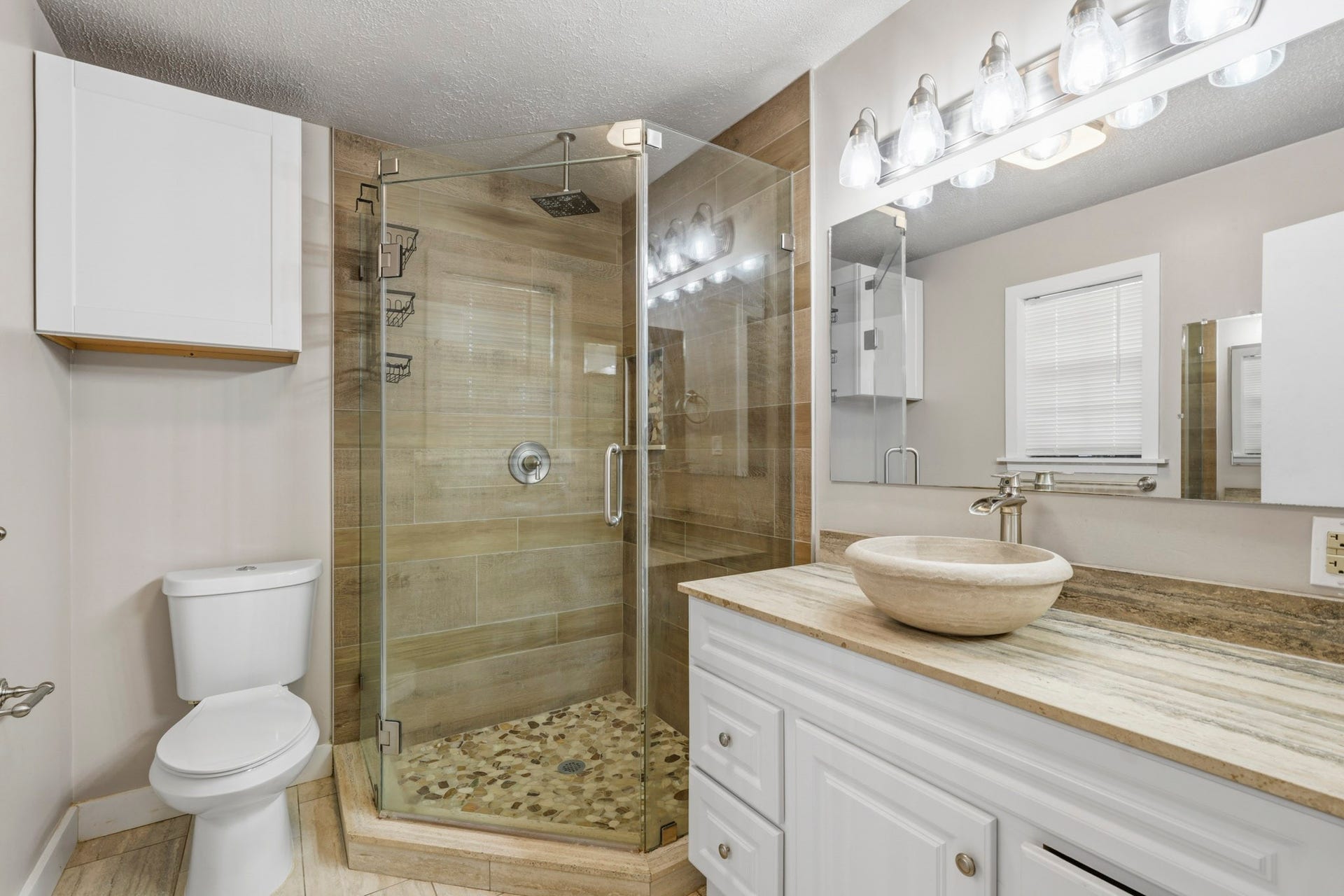 16101 Bluebird Street, Santa Fe, TX 77517 Elegant primary bathroom featuring a modern glass-enclosed shower with stone accents, a stylish vessel sink, and ample lighting.