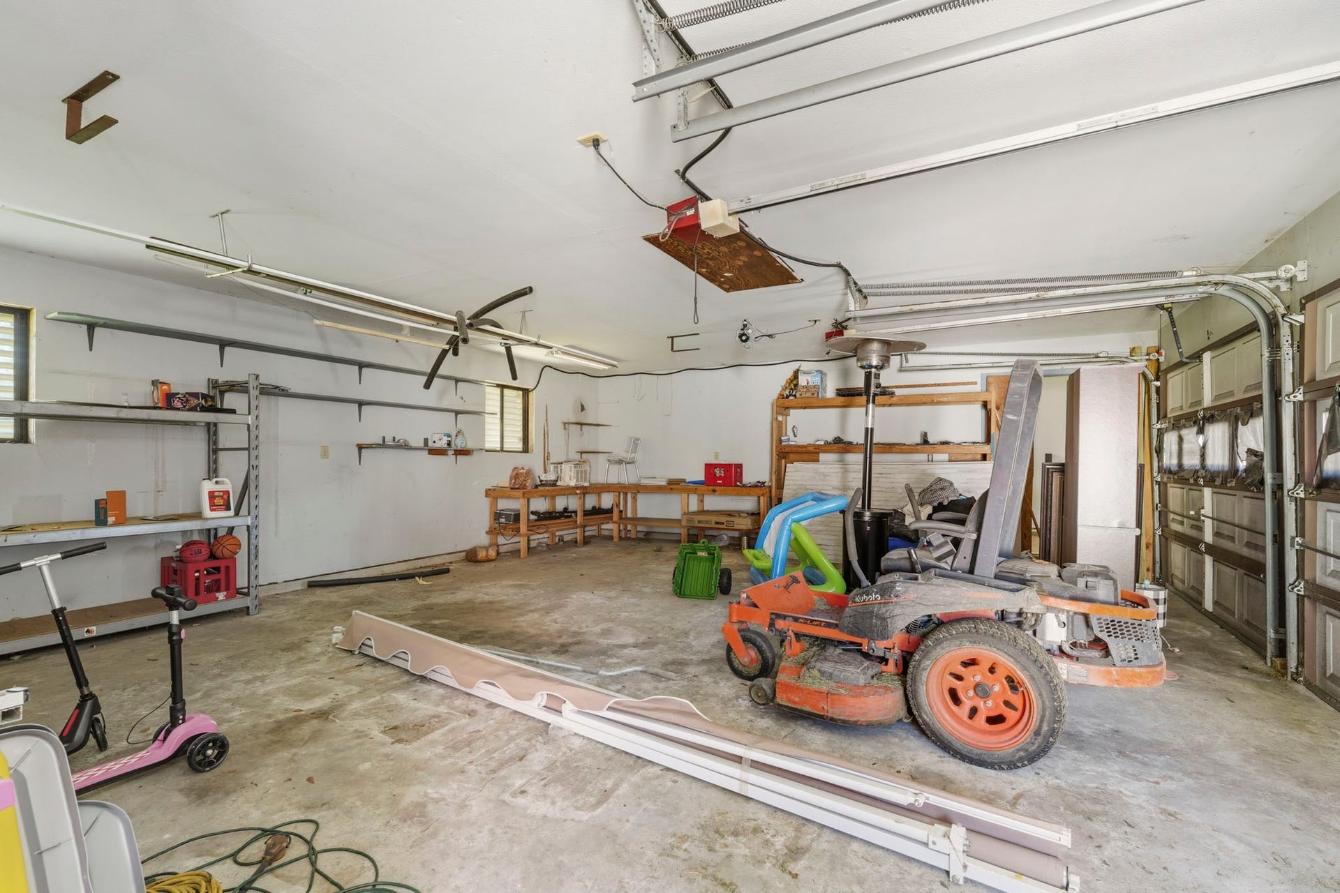 16101 Bluebird Street, Santa Fe, TX 77517 Spacious garage with ample storage shelves, workbench, and room for multiple vehicles. Ideal for hobbyists or extra storage.
