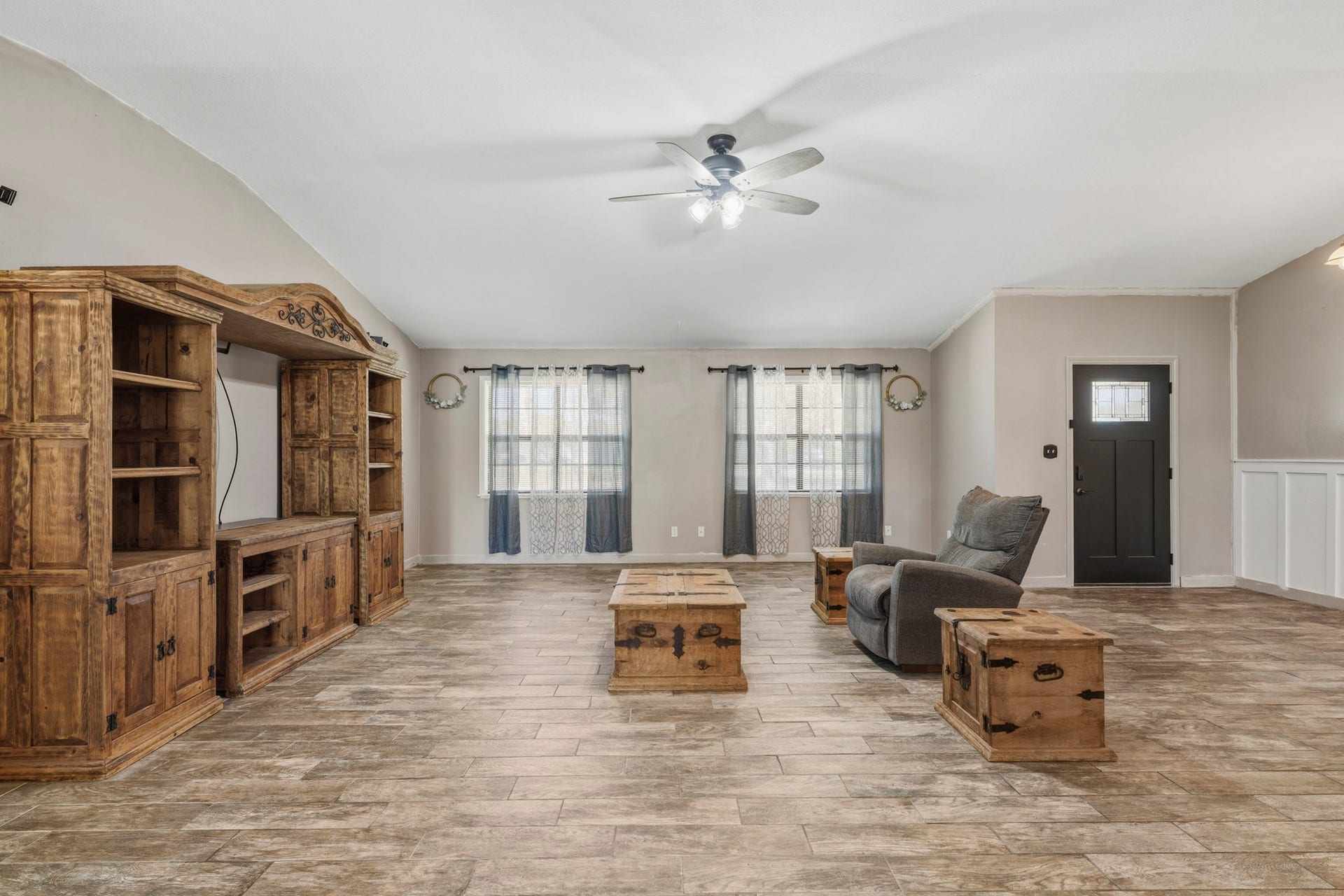 16101 Bluebird Street, Santa Fe, TX 77517 Spacious living room featuring elegant tile flooring, and abundant natural light from large windows, creating a warm and inviting atmosphere.